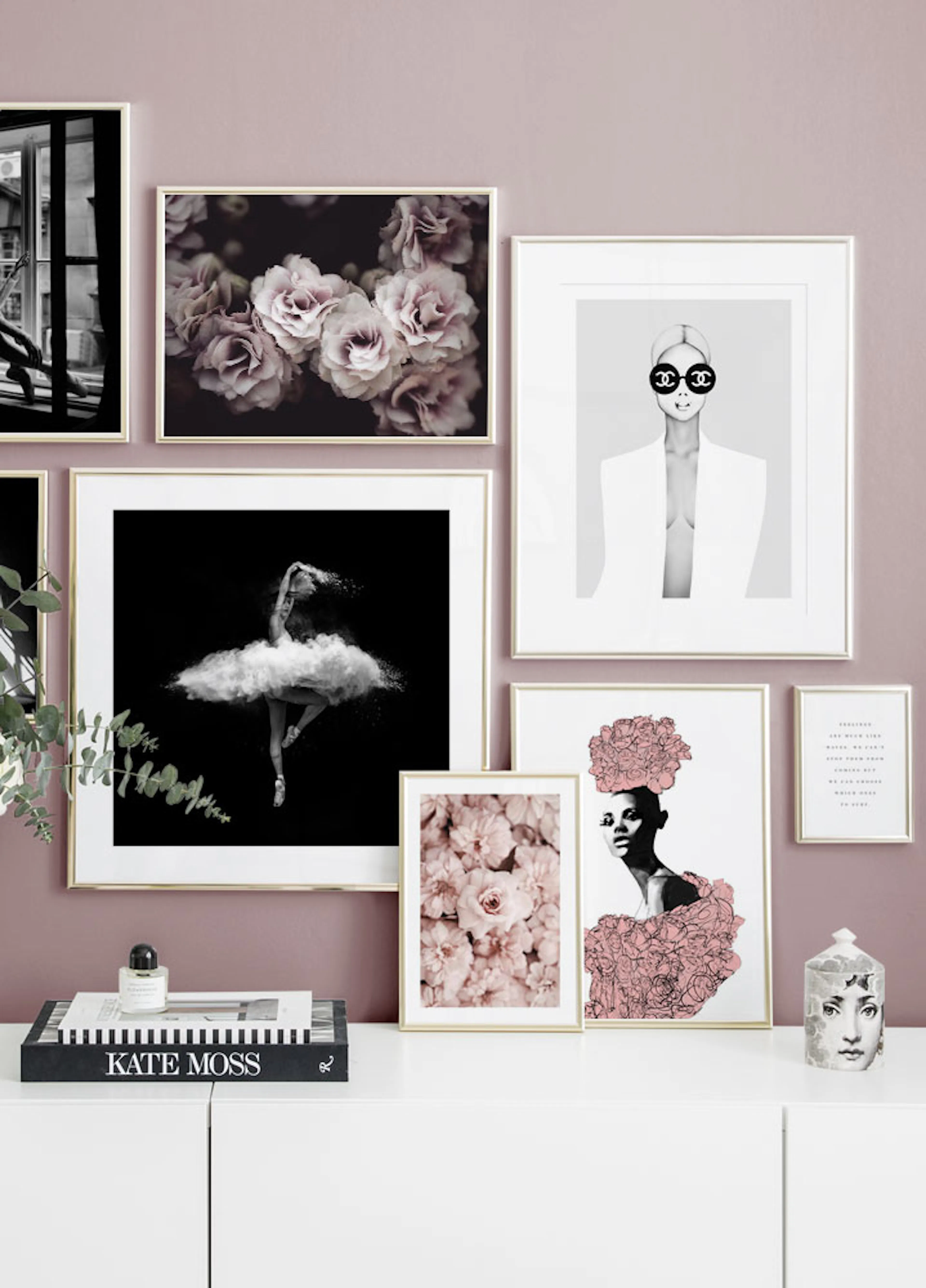 A gallery wall with various posters, including a ballerina, pink roses, and a woman in sunglasses, above a white cabinet.