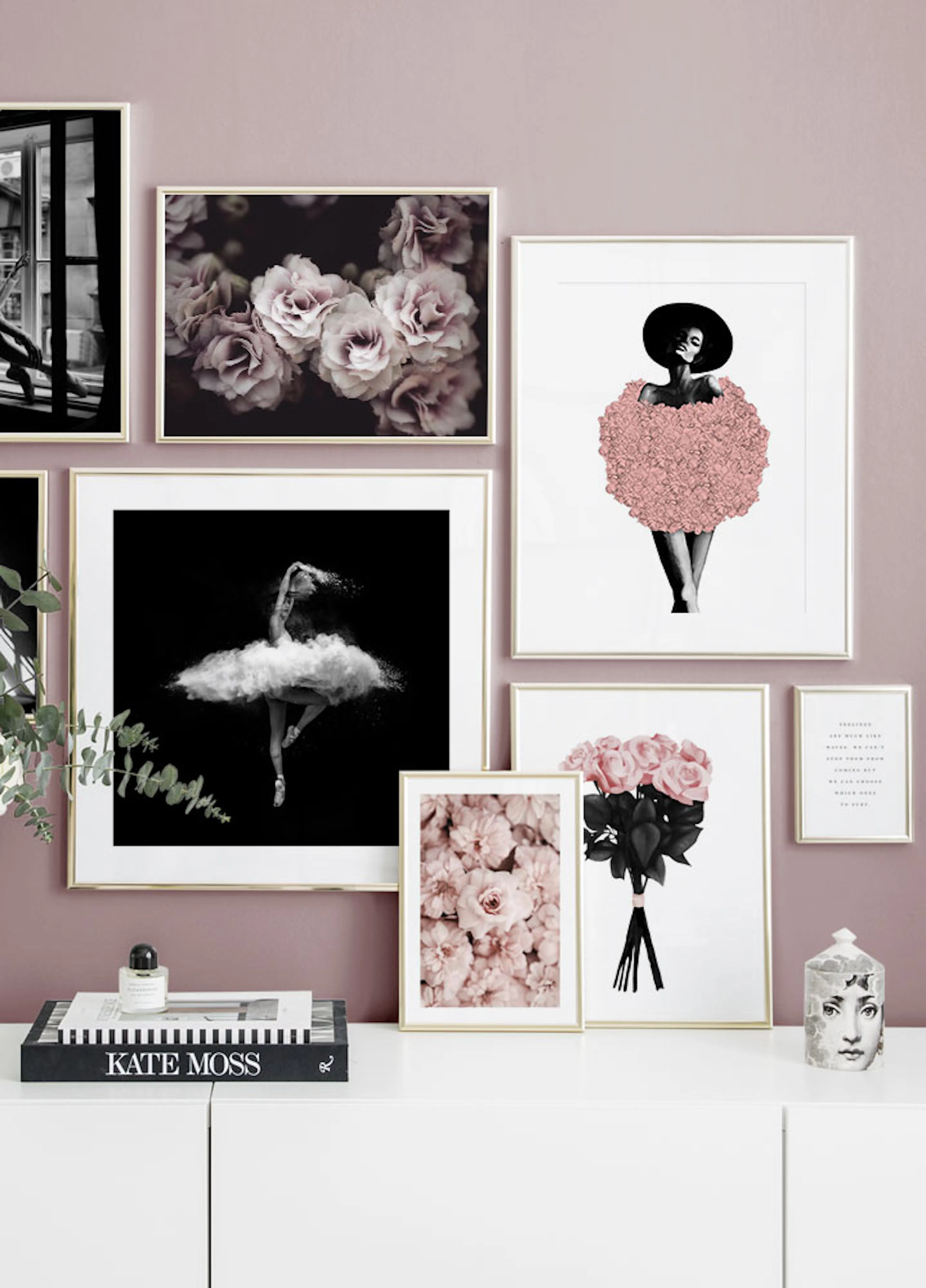 Galeriewand met posters in goudkleurige lijsten: roze bloemen, een ballerina, een vrouw met roze jurk en rozen. Hangt boven een 