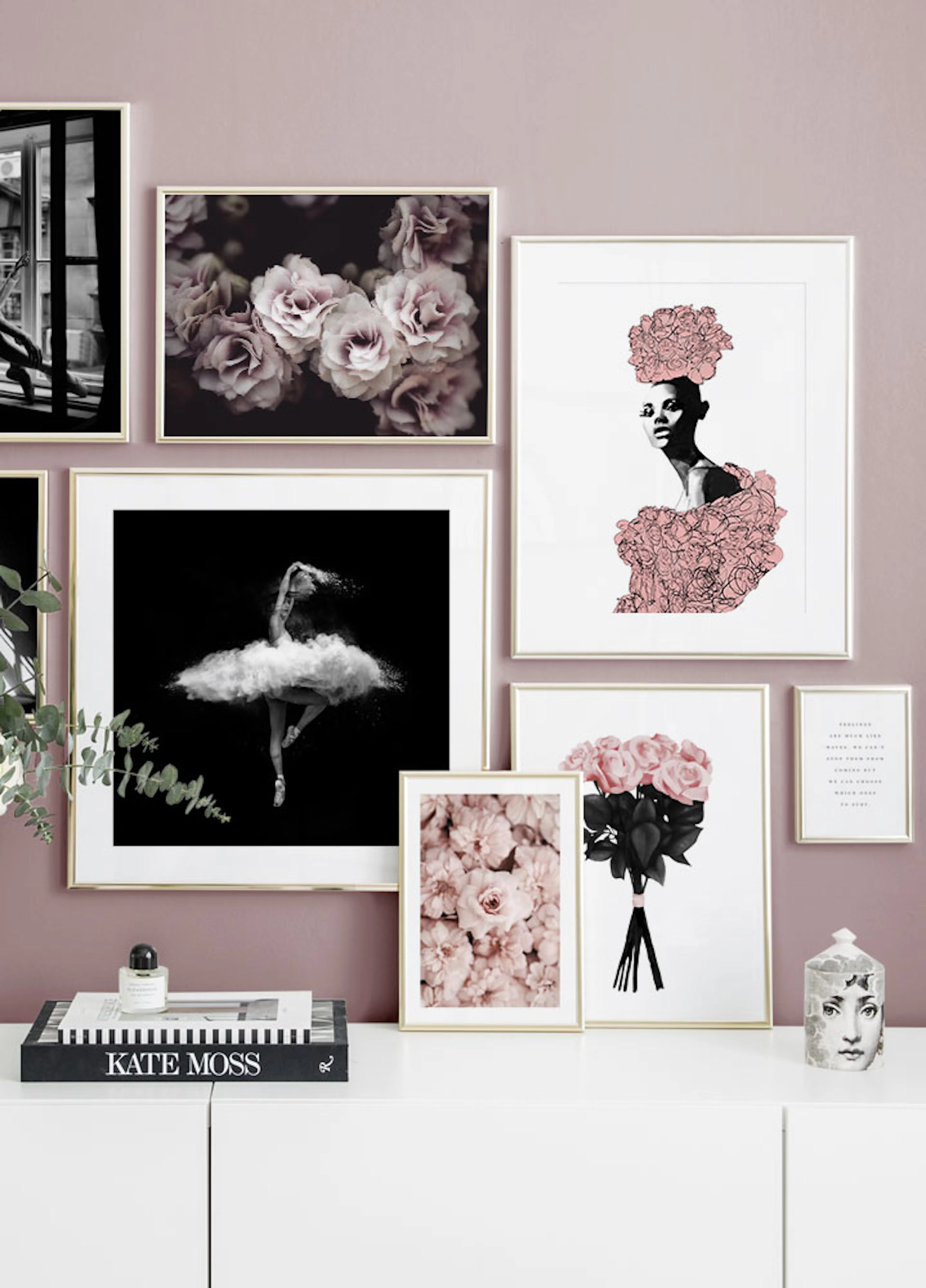 A gallery wall with posters featuring pink roses, a ballerina, and a woman in a floral dress, displayed in a living room.