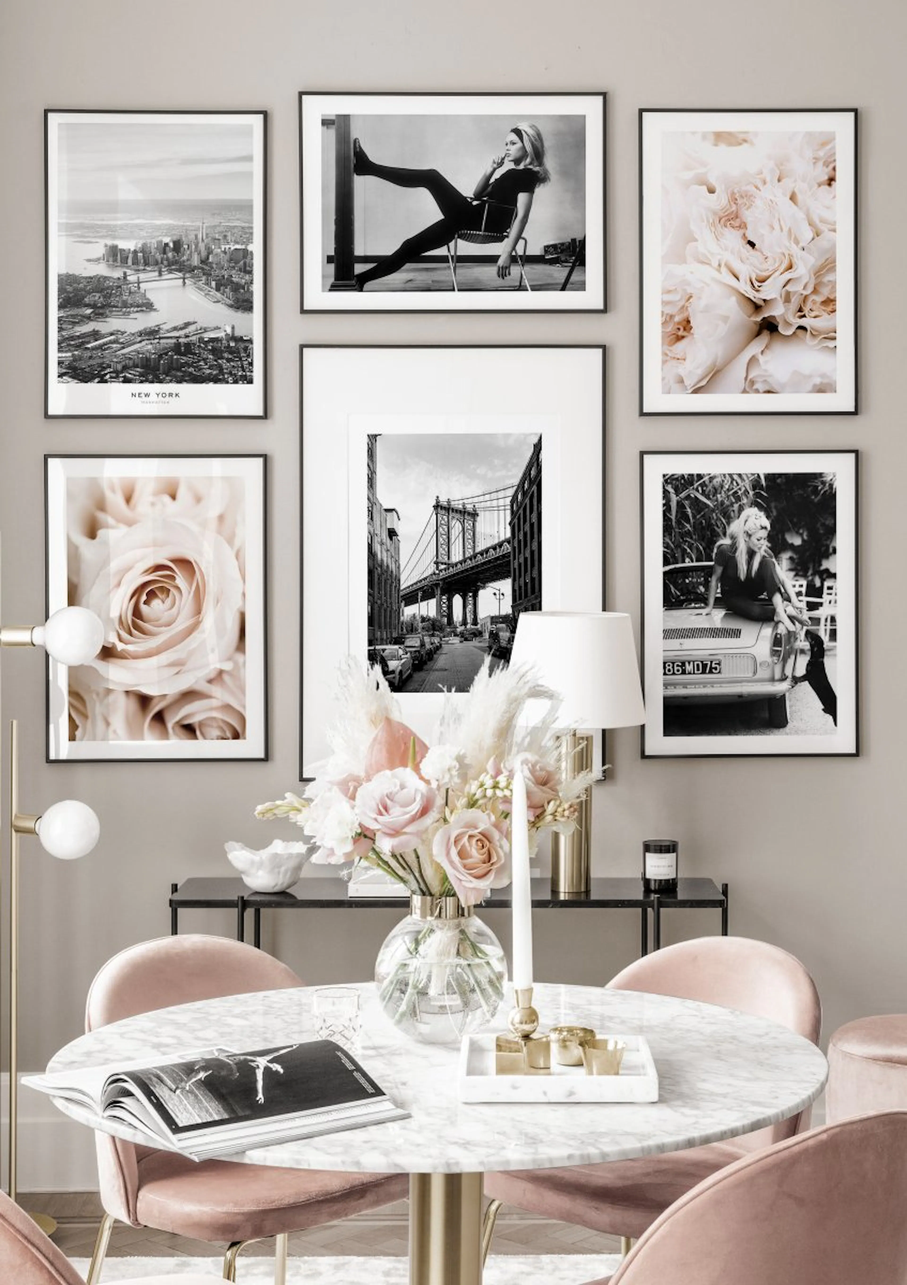 A gallery wall featuring New York posters and fashion prints, displayed above a console table with flowers in a modern dining ro