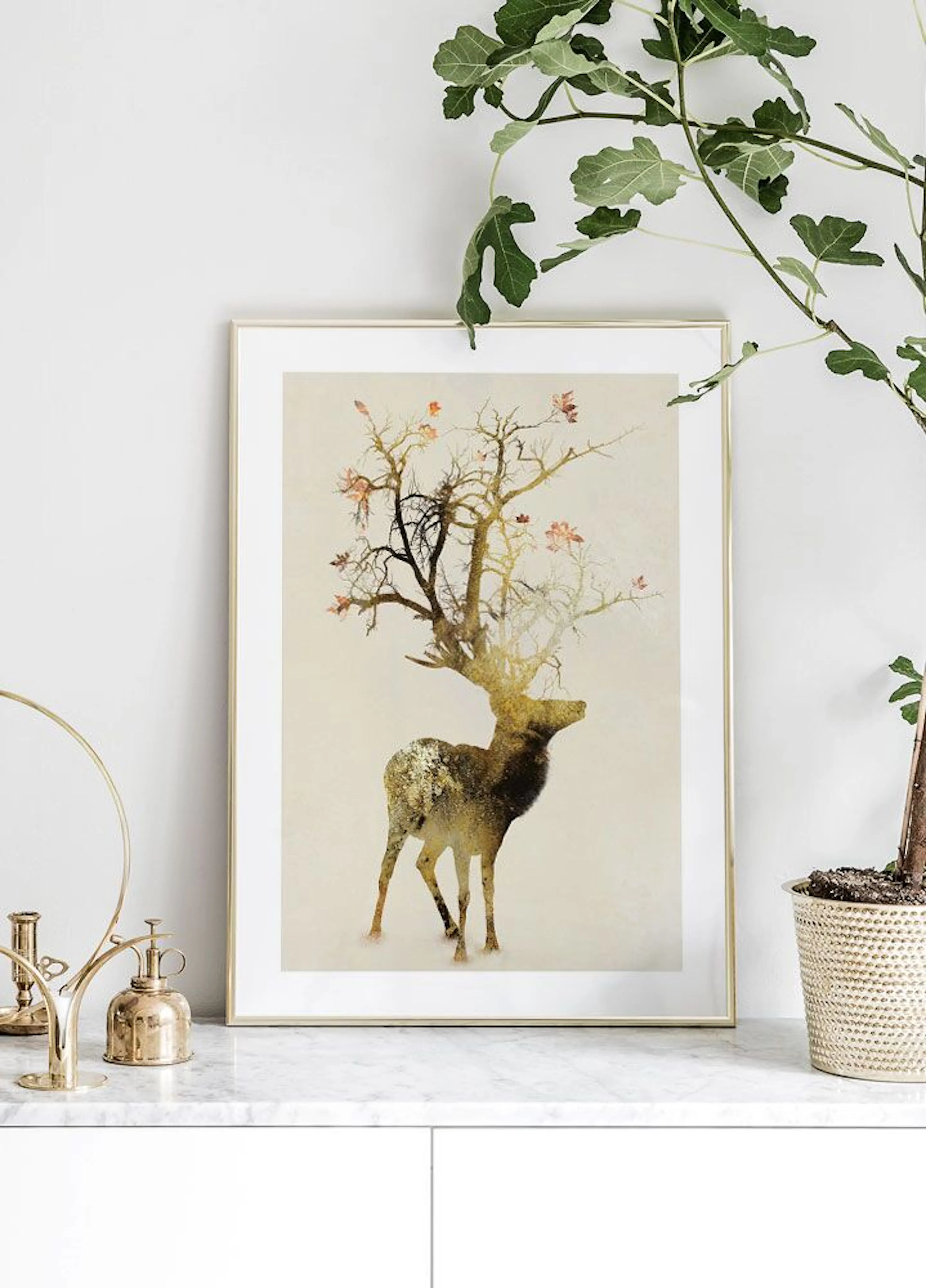 A poster of a deer with tree branches and autumn leaves as antlers, displayed on a white marble bench with plants.