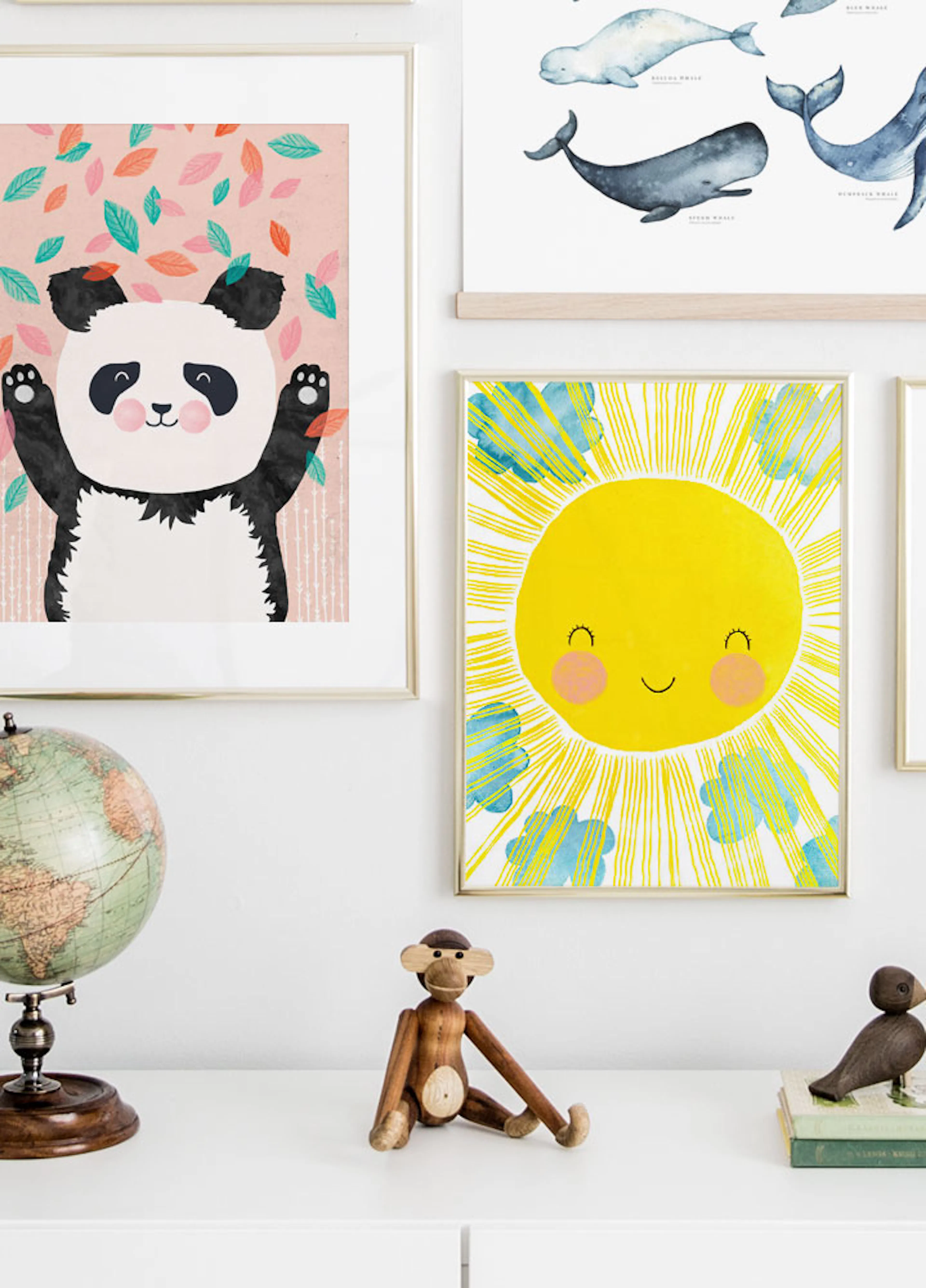 A poster of a smiling sun with yellow rays and blue clouds, displayed on a white wall above a white dresser with a wooden monkey