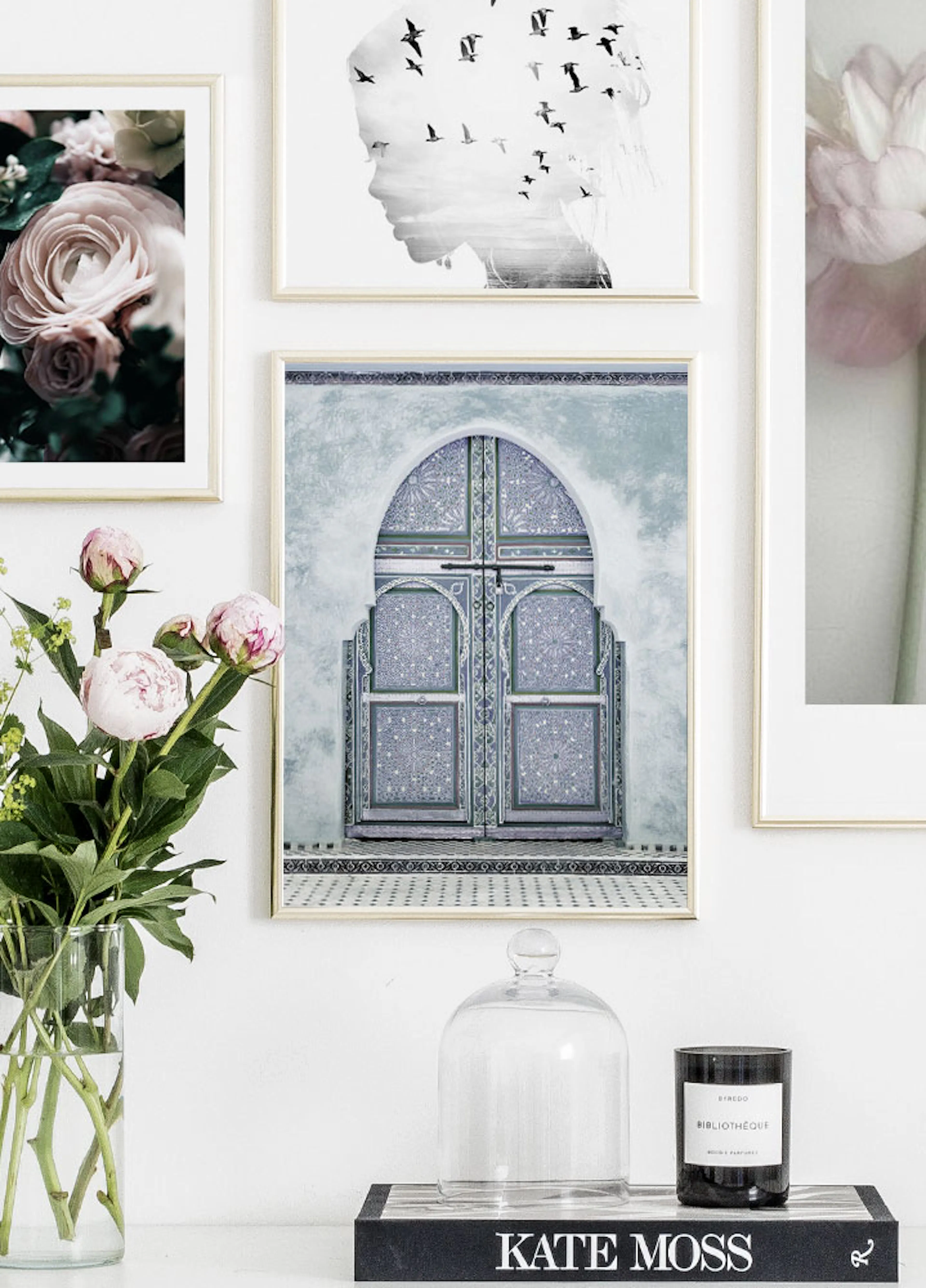A poster featuring an ornate blue Moroccan door with intricate patterns, part of a gallery wall above a white console with peoni