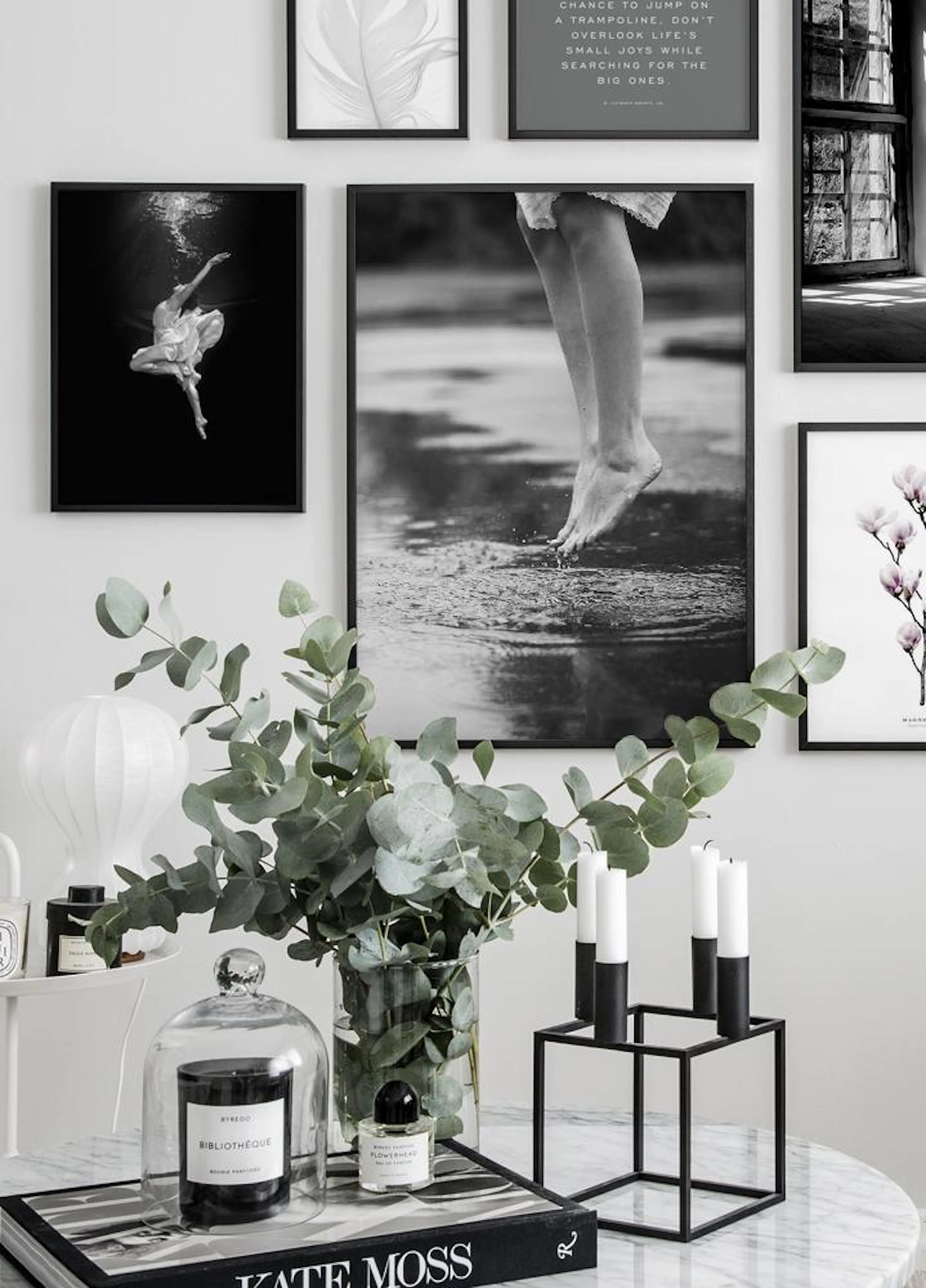 Two posters hanging on a white wall in a room; the left poster shows a ballerina underwater, and the right poster shows bare fee