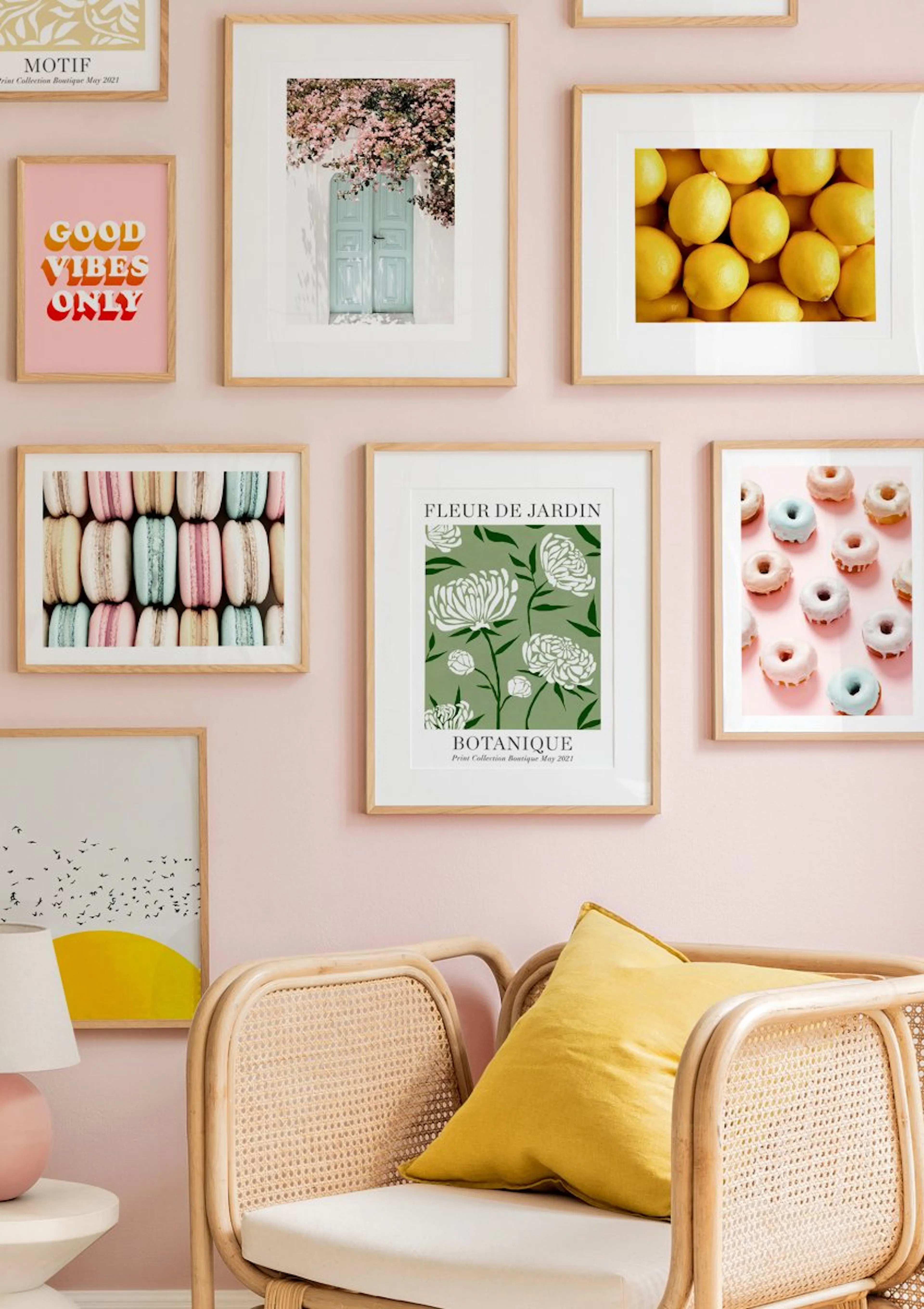 A gallery wall of posters with light wooden frames, featuring a floral print, a lemon print, and a macaron print, displayed abov