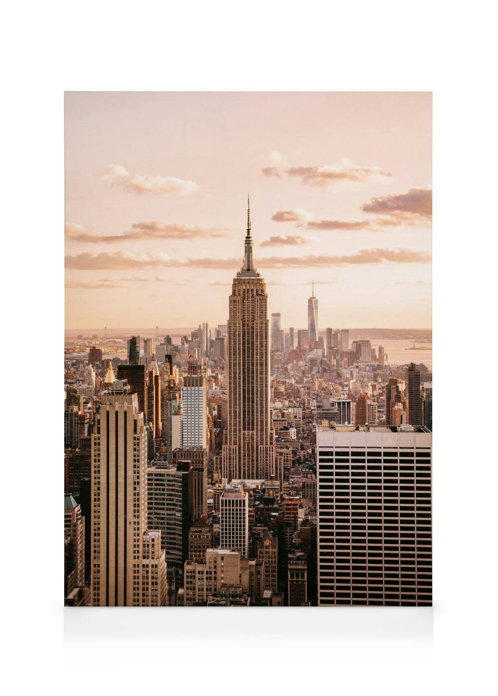 Leinwandbild mit einer Drohnenansicht der New Yorker Skyline bei Sonnenuntergang, mit dem Empire State Building im Vordergrund.