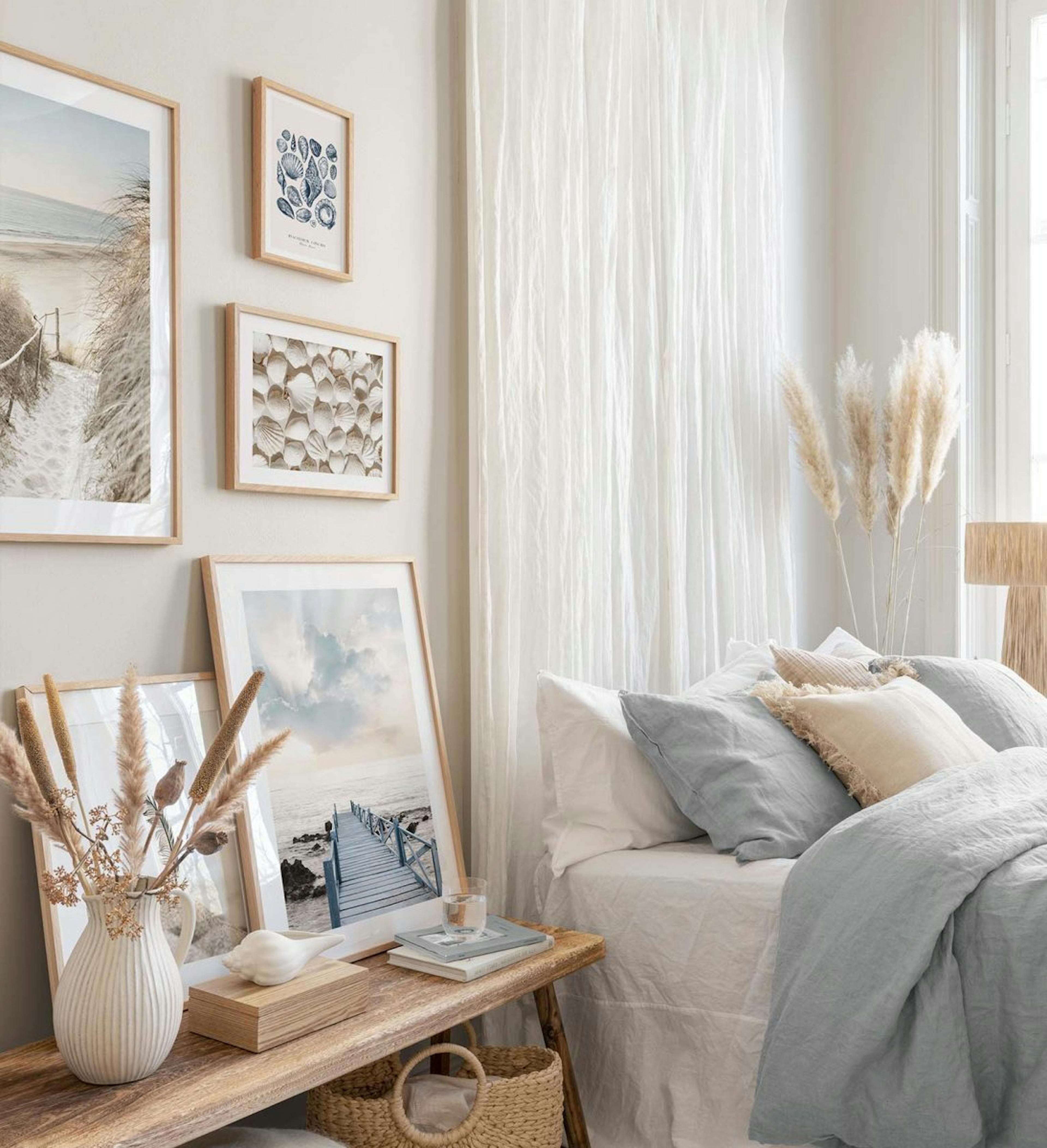 Gallery wall with beach posters in blue and beige colours with oak frames for bedroom