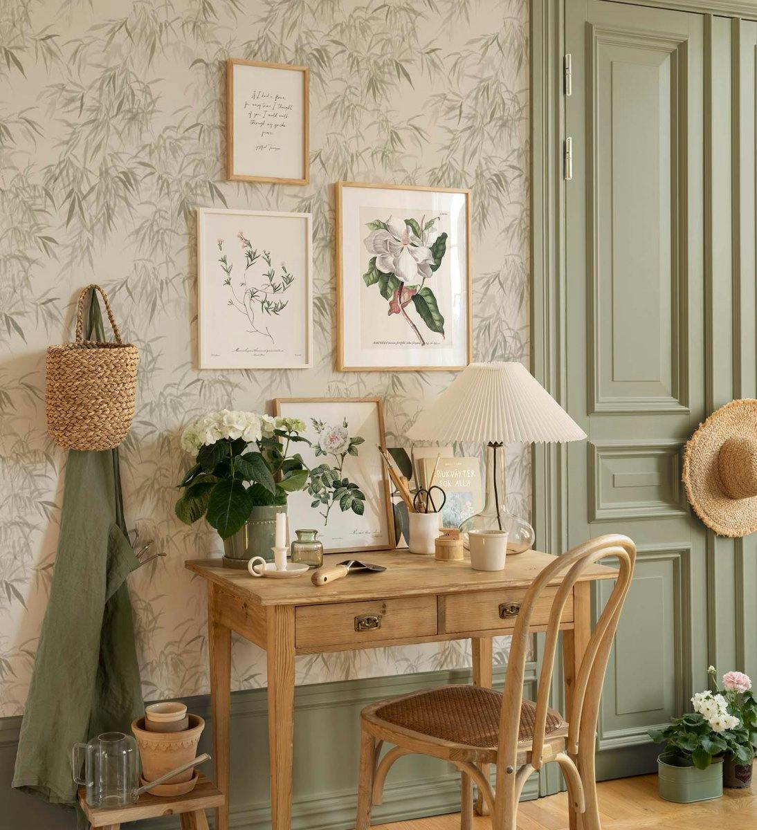 Un poster botanique dune fleur de magnolia blanche avec des feuilles vertes, suspendu au-dessus dun bureau en bois.