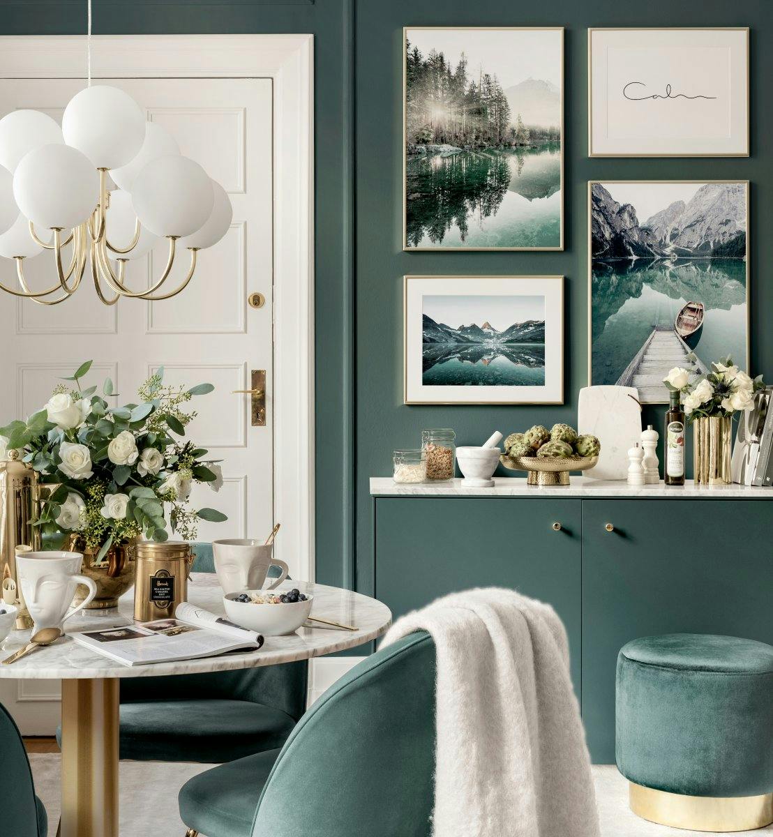 A set of four nature-inspired posters, including a serene lake, mountains, and a boat, displayed on a dark green wall.