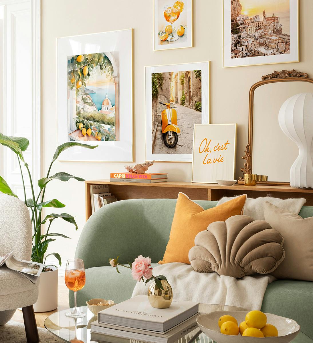 Décoration murale avec des affiches de paysages méditerranéens, un scooter jaune et un cocktail aux agrumes, créant une ambiance