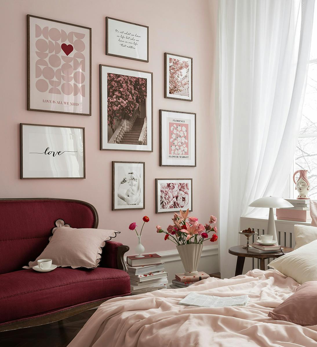 A gallery wall with eight prints featuring inspirational quotes, florals, and abstract shapes in a pink and white color palette.