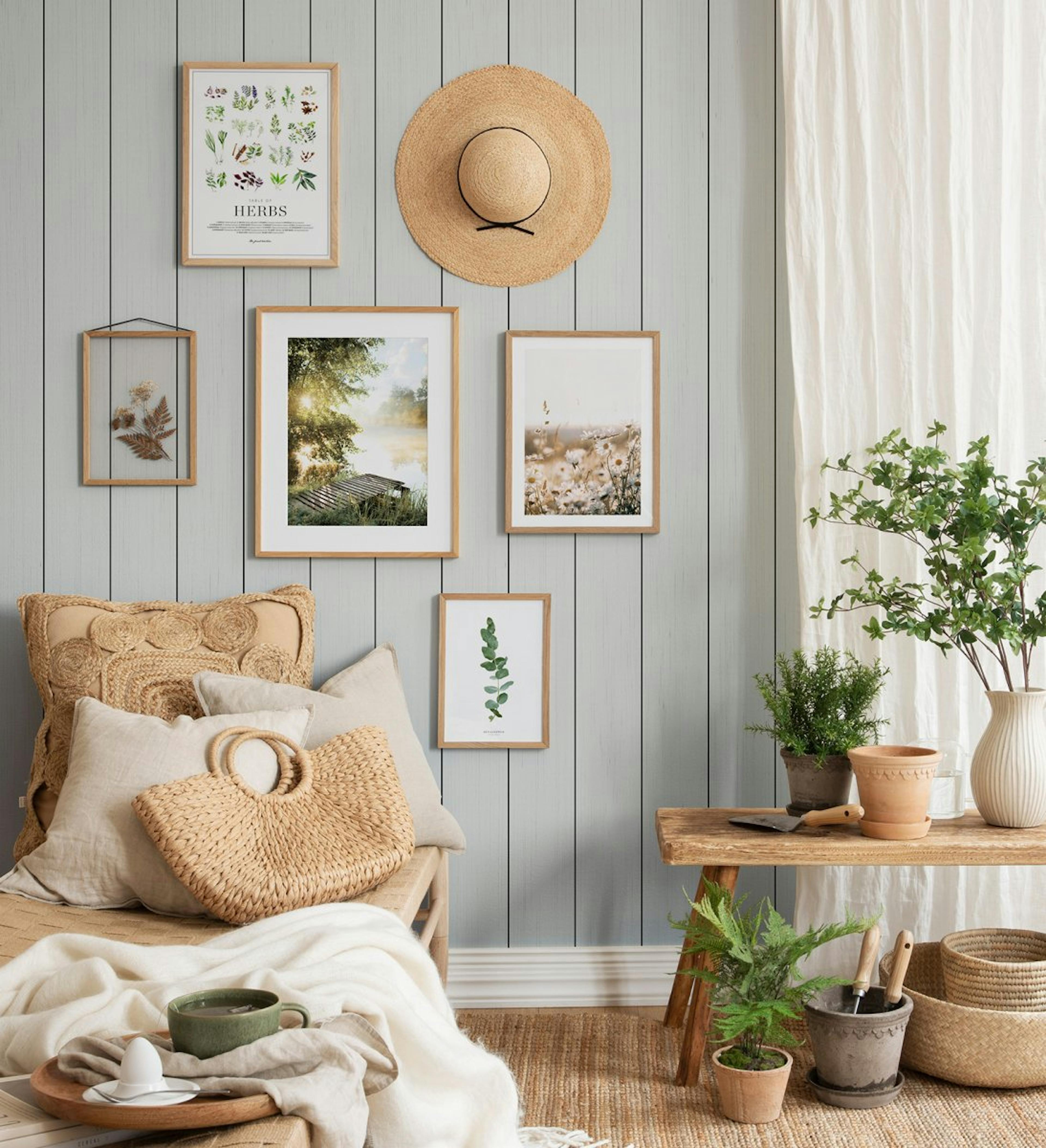 Nature gallery wall with calm elements of botanical prints and photographs with oak frames for living room or hallway