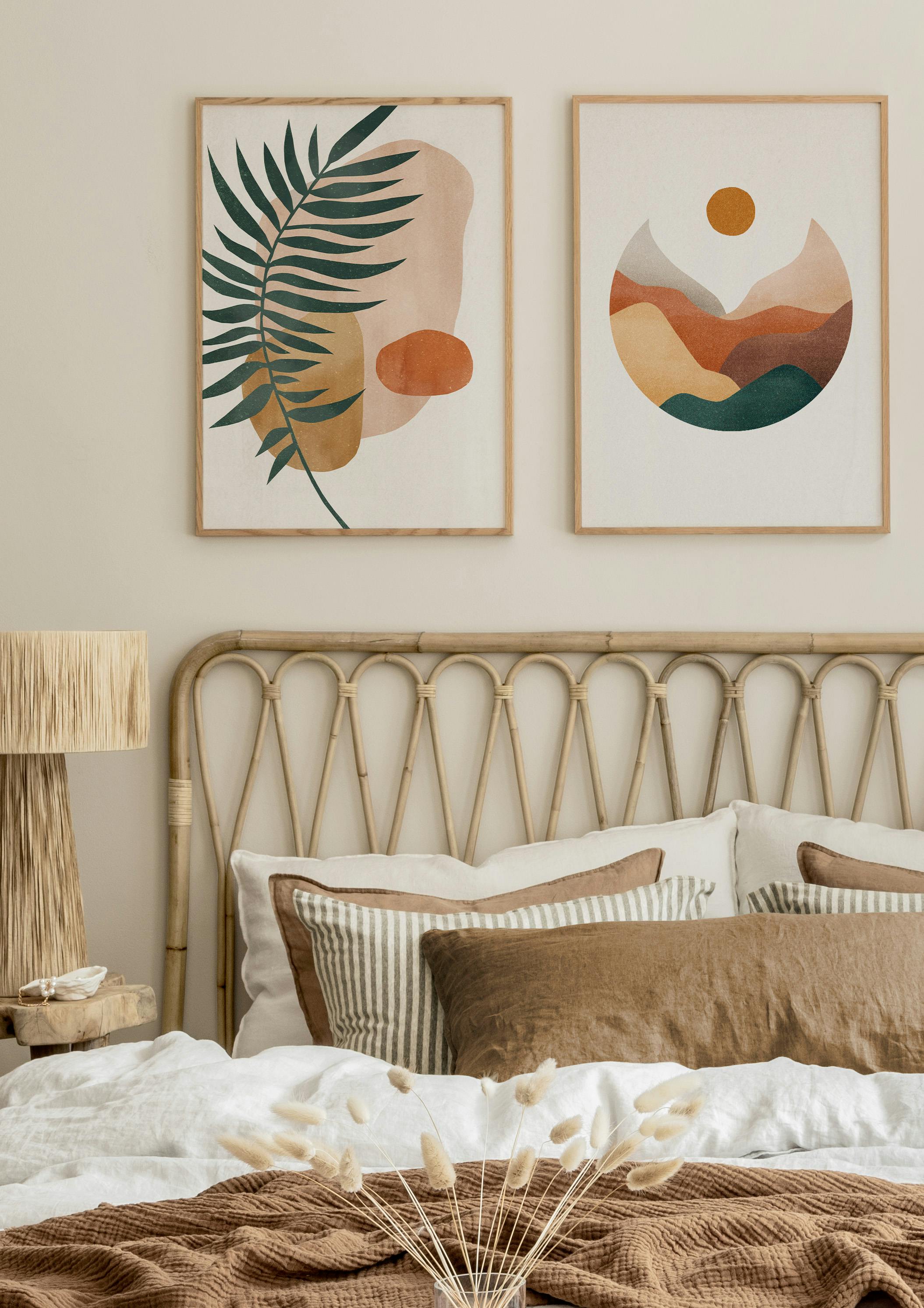 Ein Posterset mit abstrakten Darstellungen von grünen Blättern und einer Landschaft in Erdtönen über einem Bett.