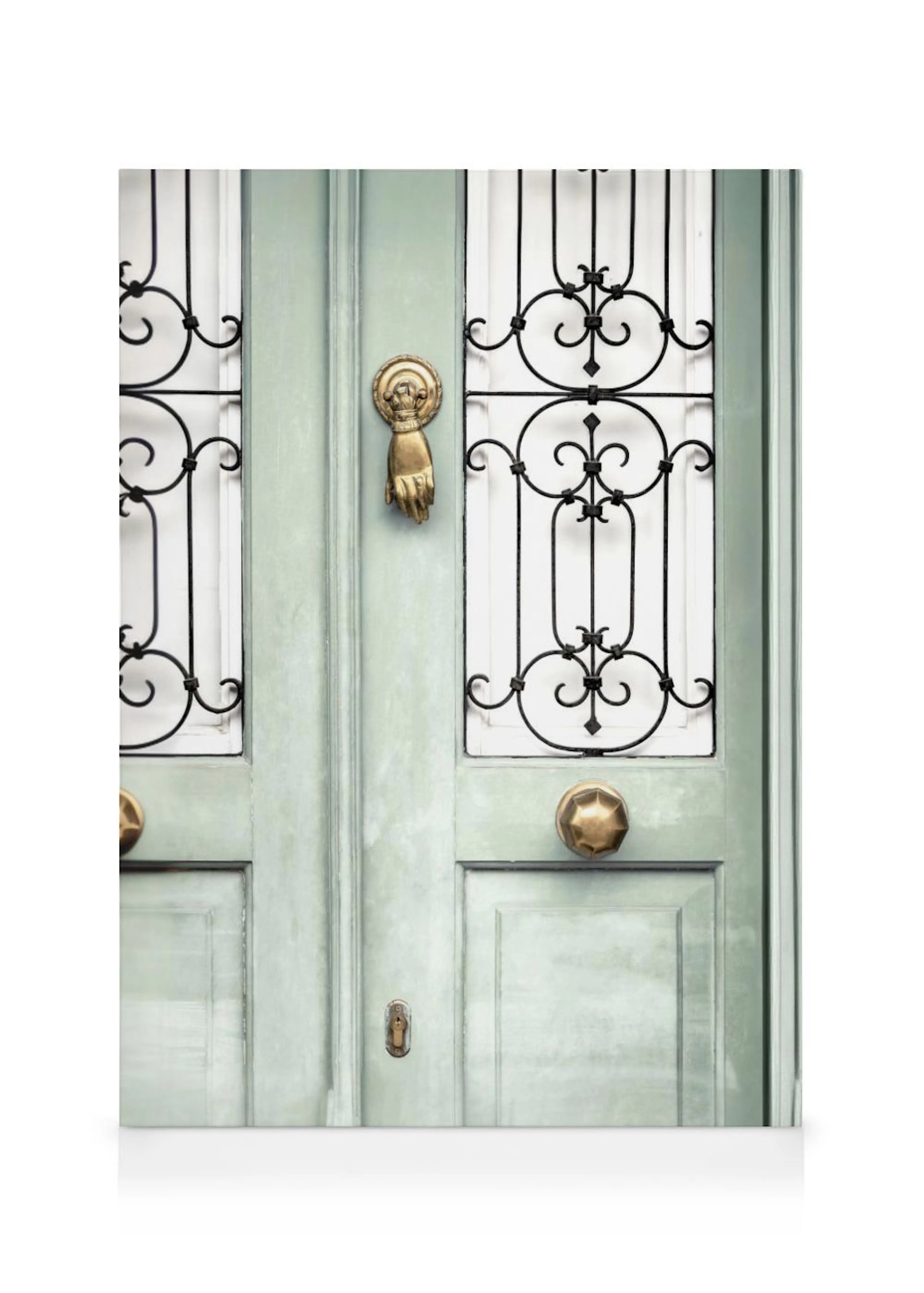 A canvas showing a mint green door with a golden hand-shaped knocker, brass doorknobs, and decorative black ironwork.