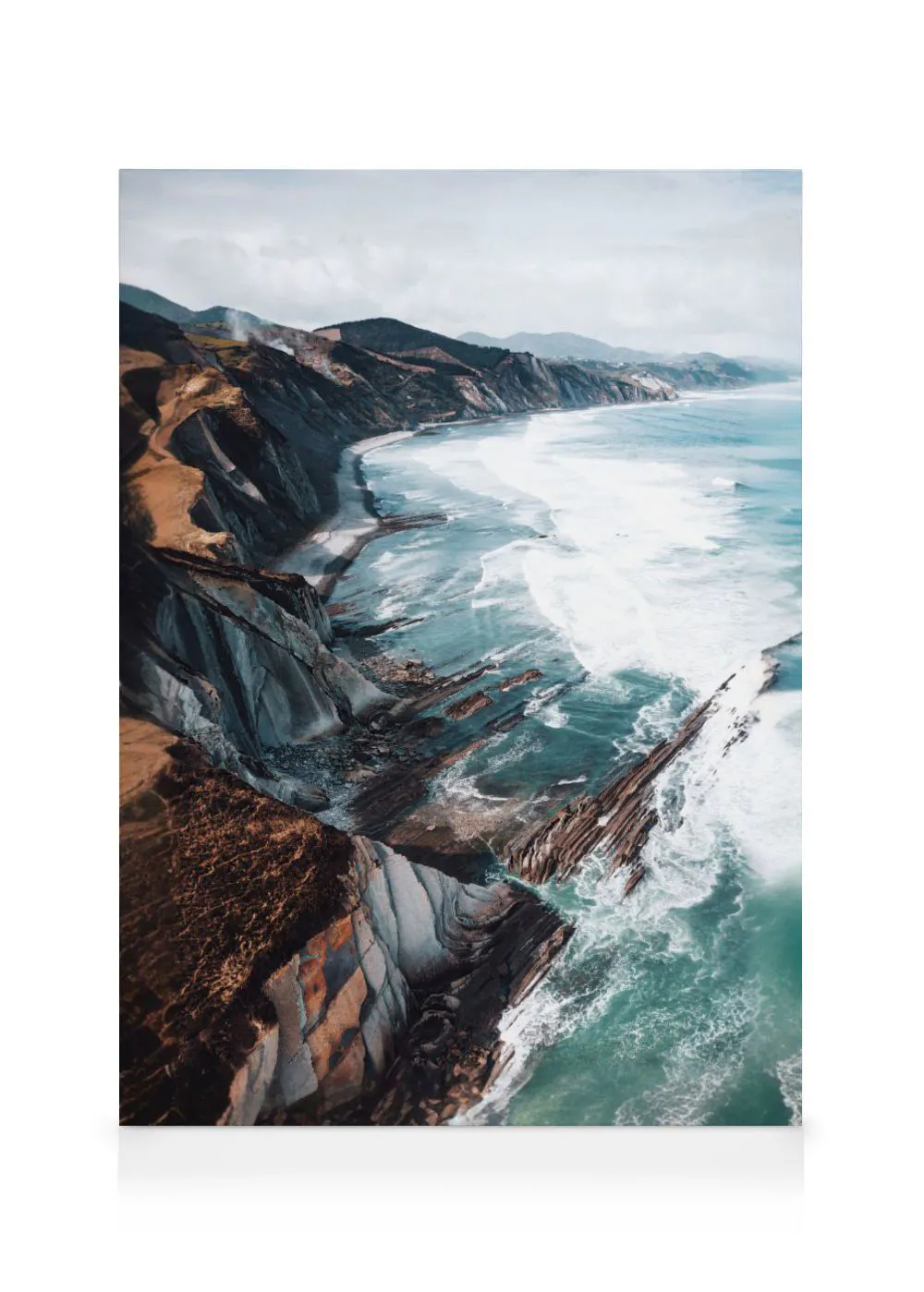 A canvas showing a dramatic coastal landscape with rugged cliffs, dark rock formations, and turquoise ocean waves crashing on th