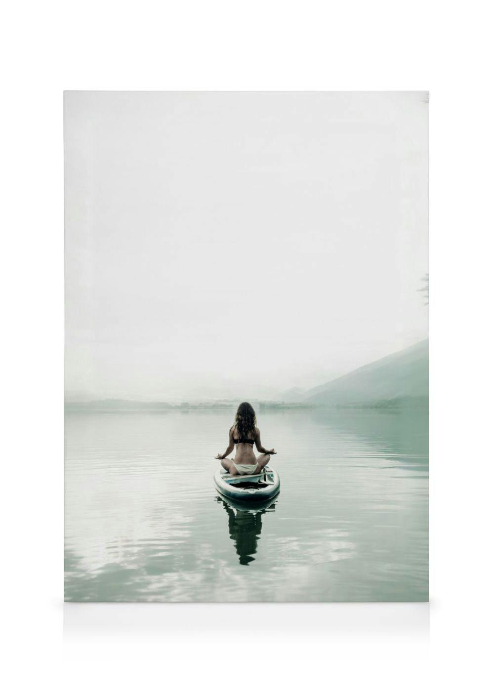 A canvas showing a woman meditating on a paddleboard in the middle of a calm lake with mountains in the background.