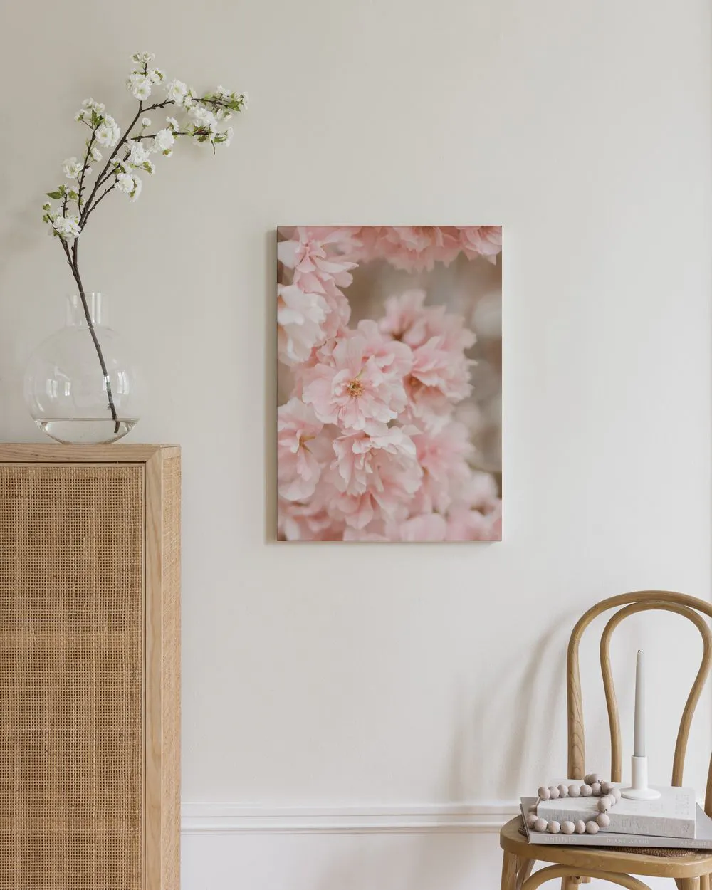 Stampa su tela di fiori di ciliegio rosa chiaro, appesa in un ambiente moderno con mobili in legno.