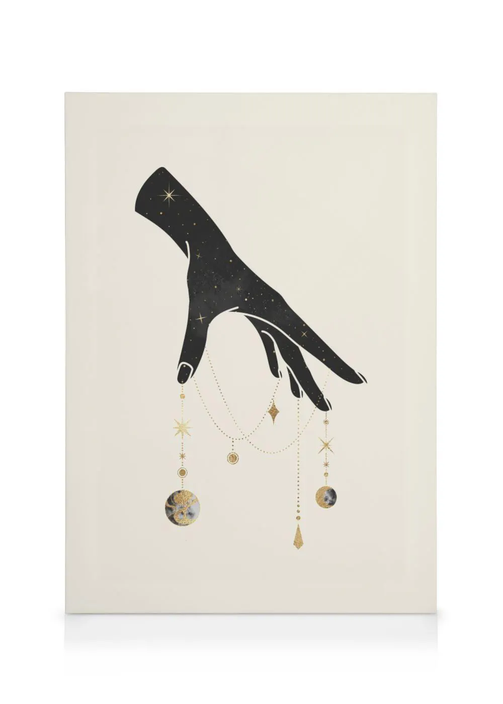 Mystical canvas with a black, star-filled hand dangling gold celestial elements and moon phases against a cream background.