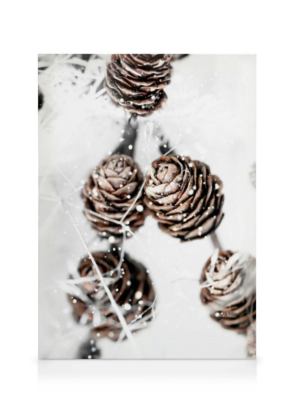 Toile représentant des pommes de pin enneigées sur fond clair, avec des touches de blanc et de marron.