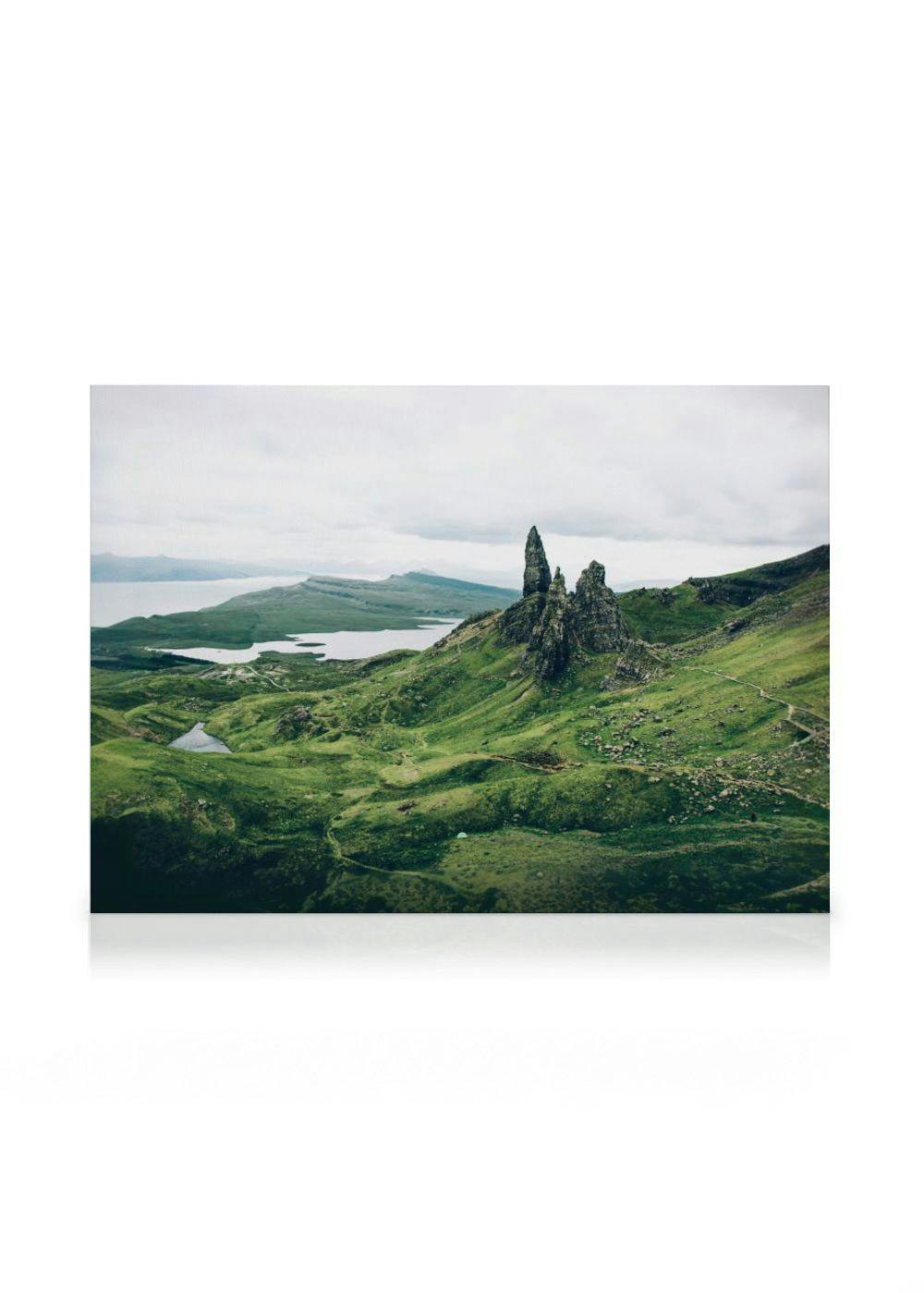 A canvas displaying the Old Man of Storr, a rugged rock formation on a green hillside under a cloudy sky in Scotland.