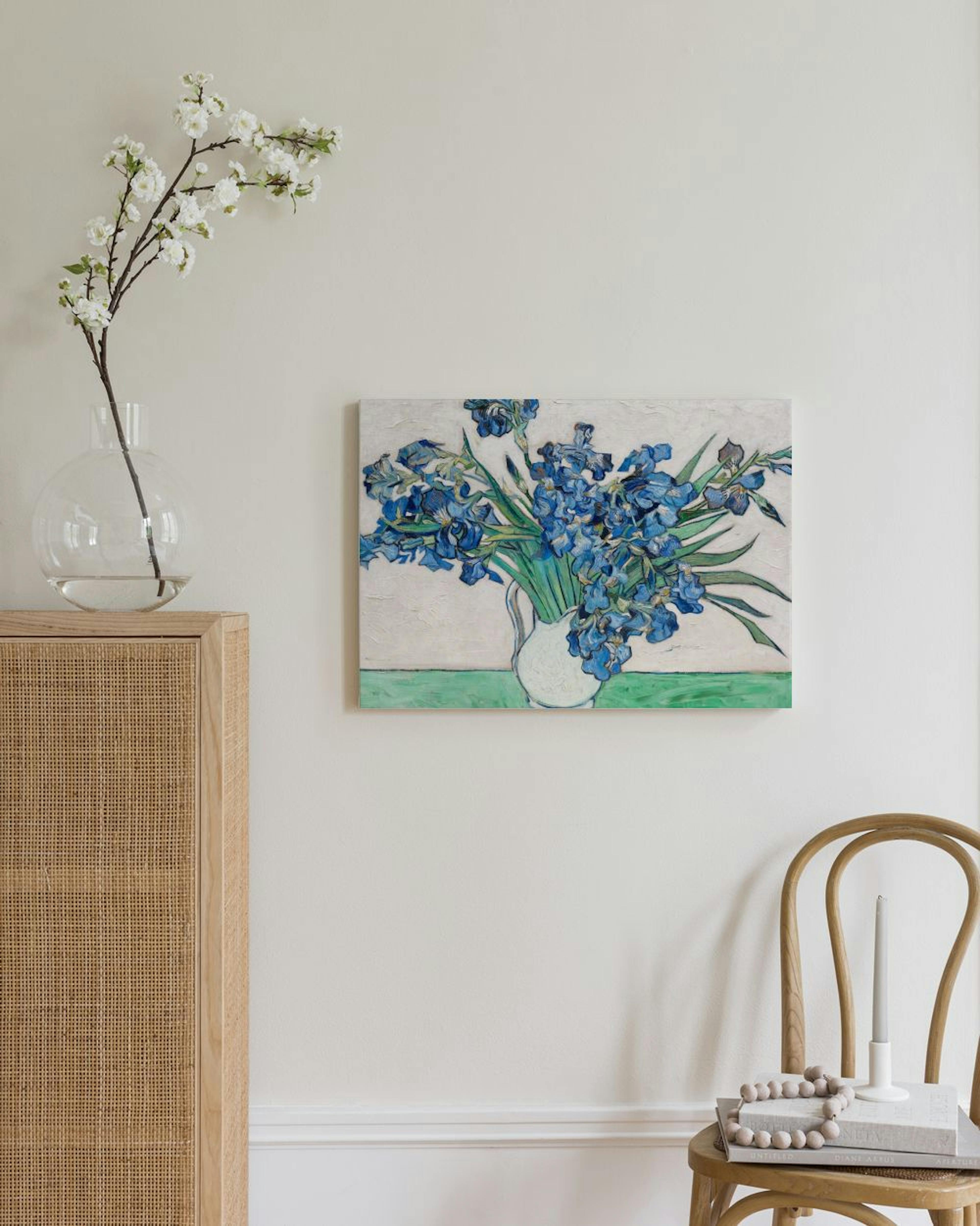 Leinwandbild mit Van Goghs blauen Iris in einem Krug, an einer hellen Wand im Wohnzimmer hängend.