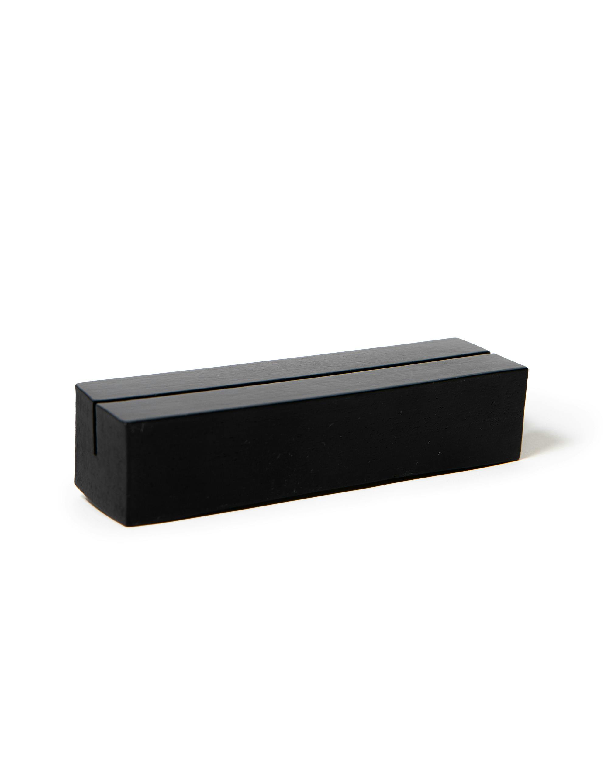 Soporte negro rectangular para póster con una ranura superior, sobre fondo blanco.