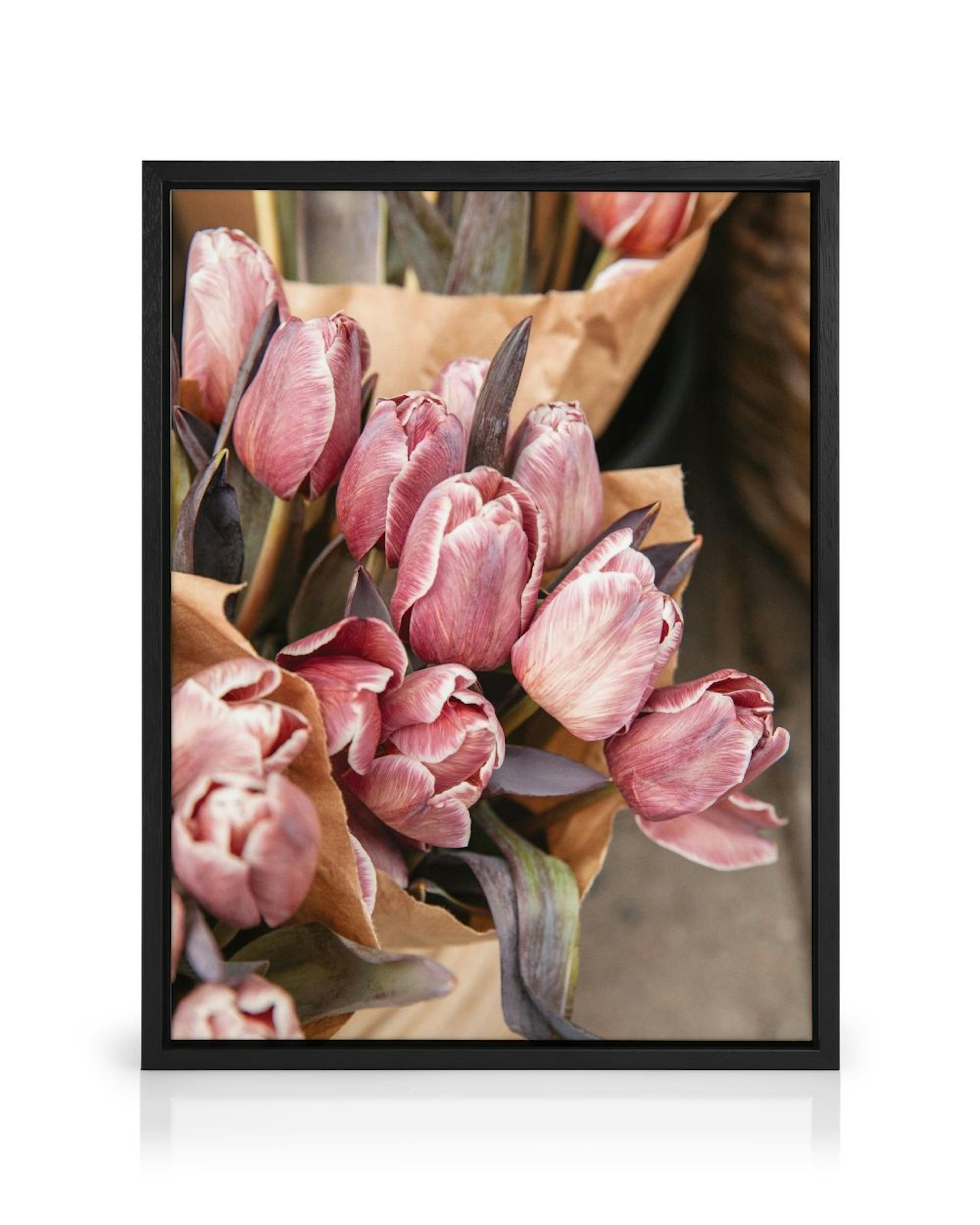 A canvas displaying a bouquet of pink and white striped tulips wrapped in brown paper, with dark green leaves.