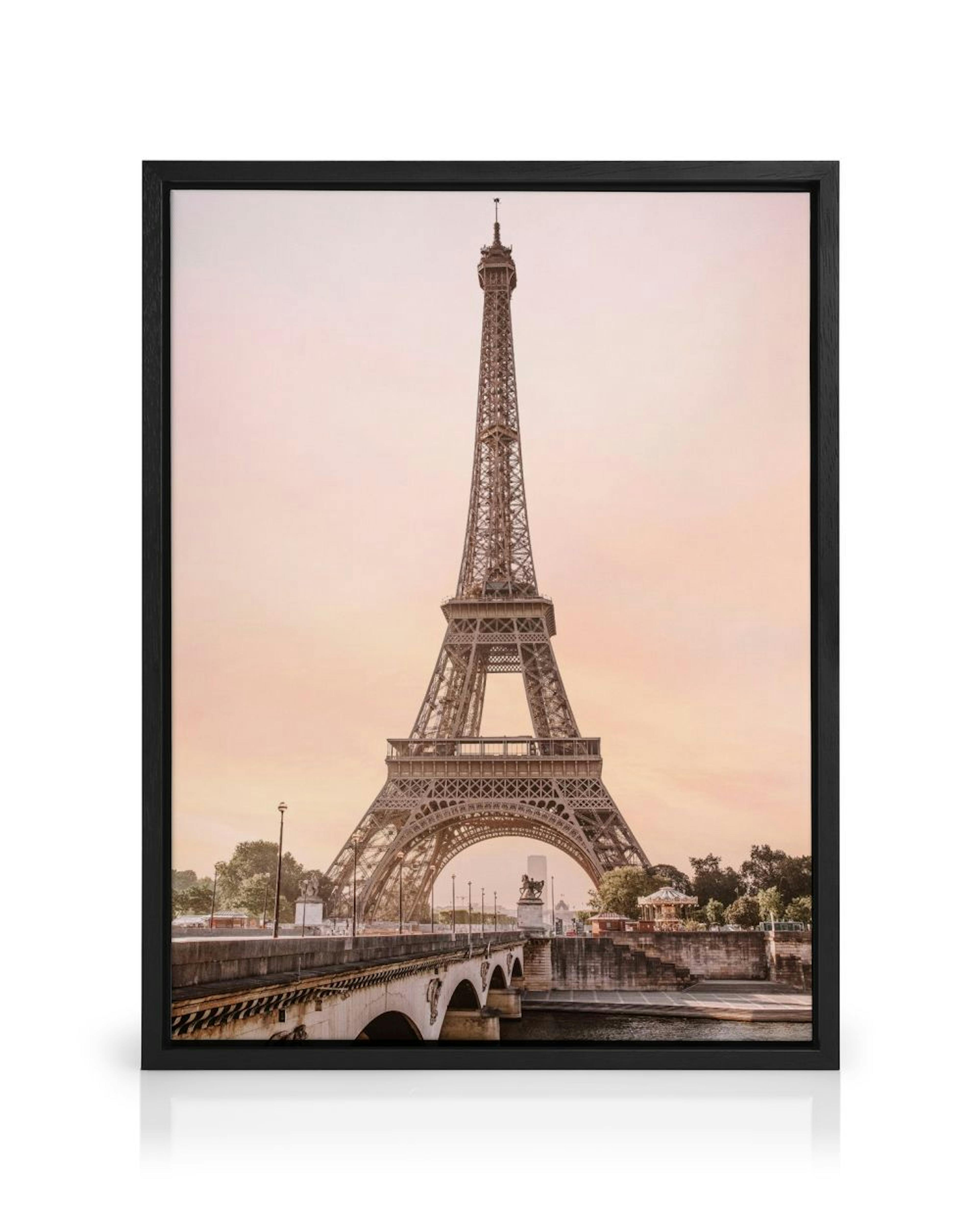 A canvas featuring the Eiffel Tower in Paris, with a bridge over the Seine River and a carousel under a pink sky.