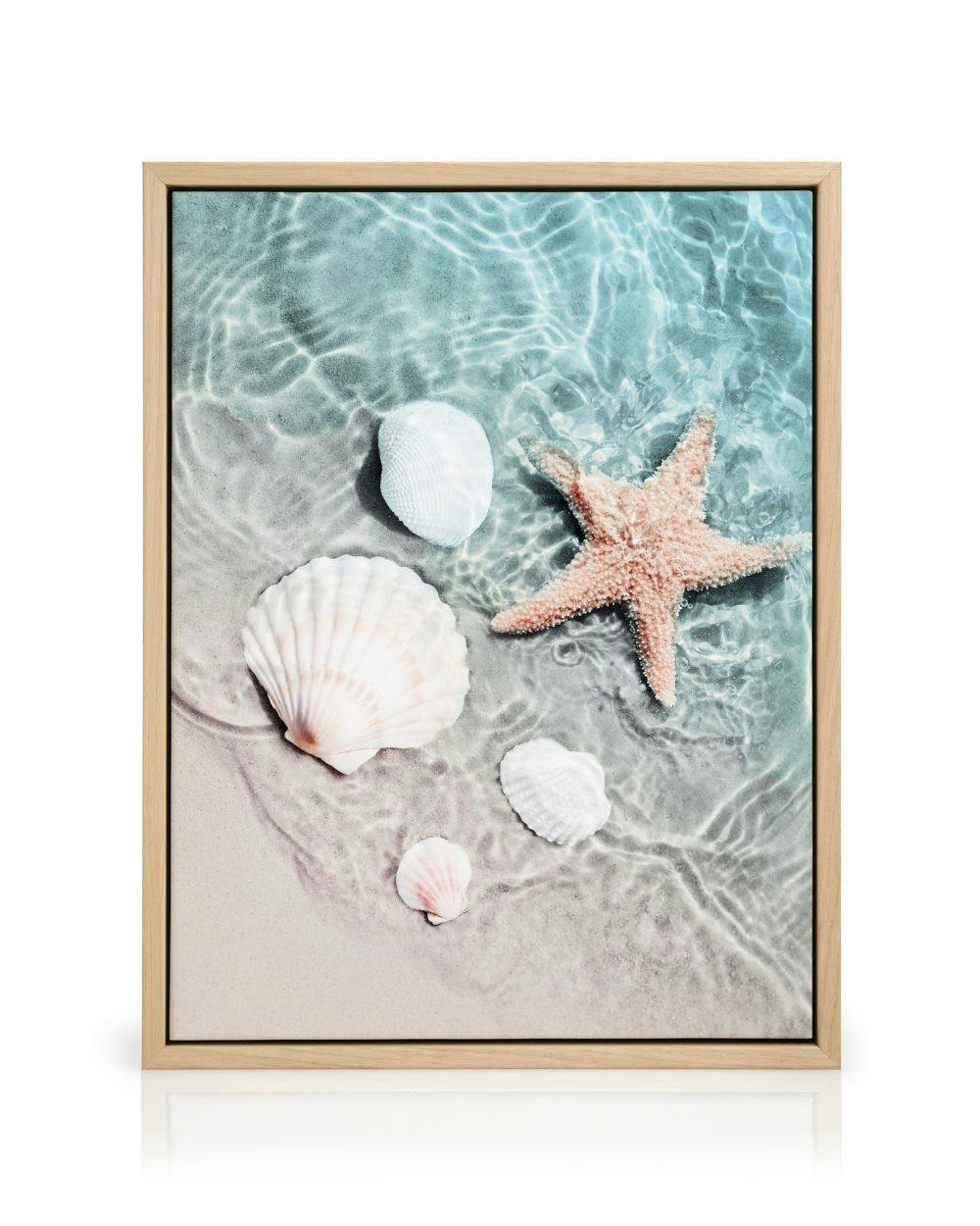 Canvastavla med stranddetaljer som en rosa sjöstjärna och vita snäckor under vattenytan på sand.