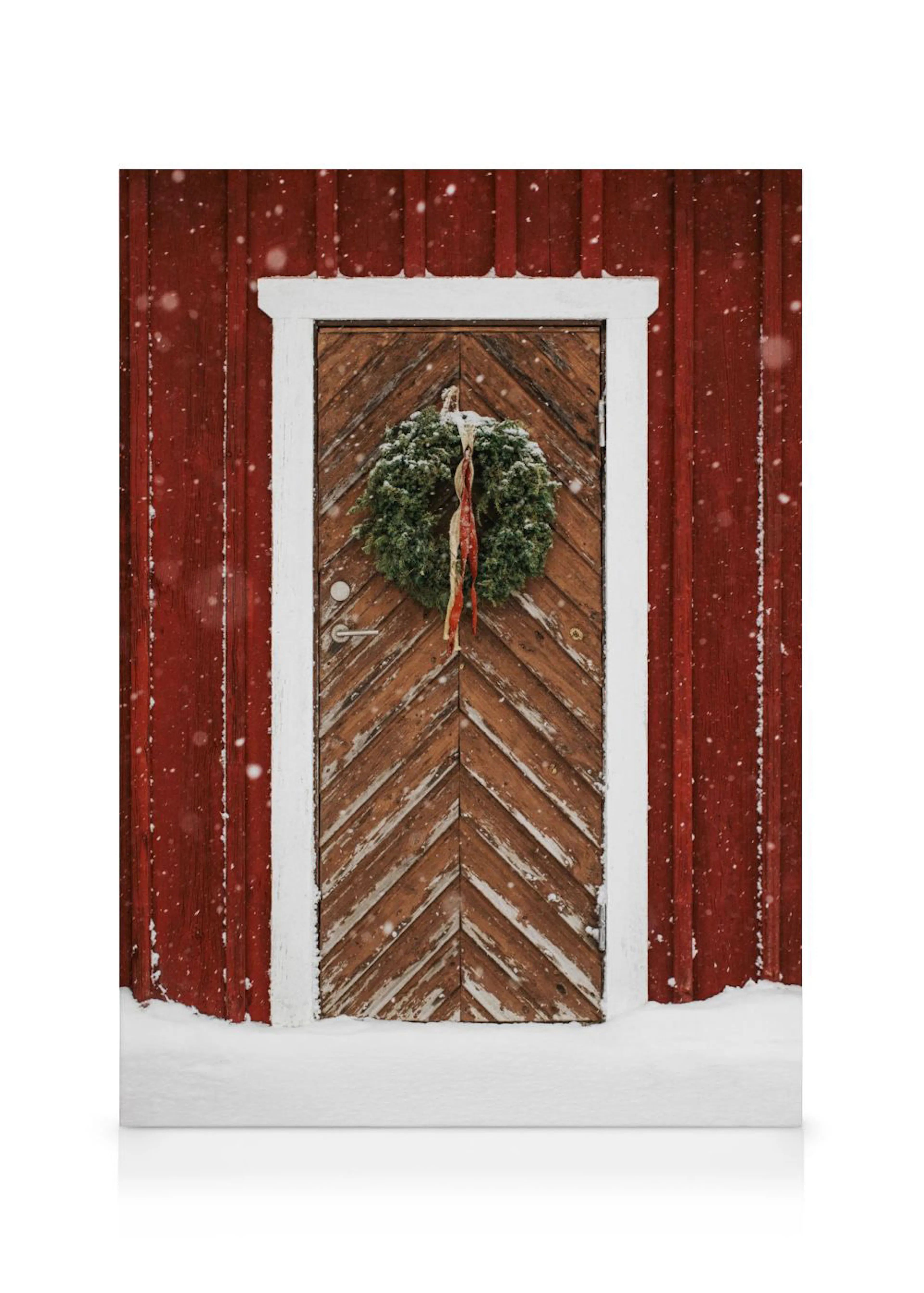 Toile dune porte en bois rustique rouge et marron, ornée dune couronne de Noël et de neige fraîche.