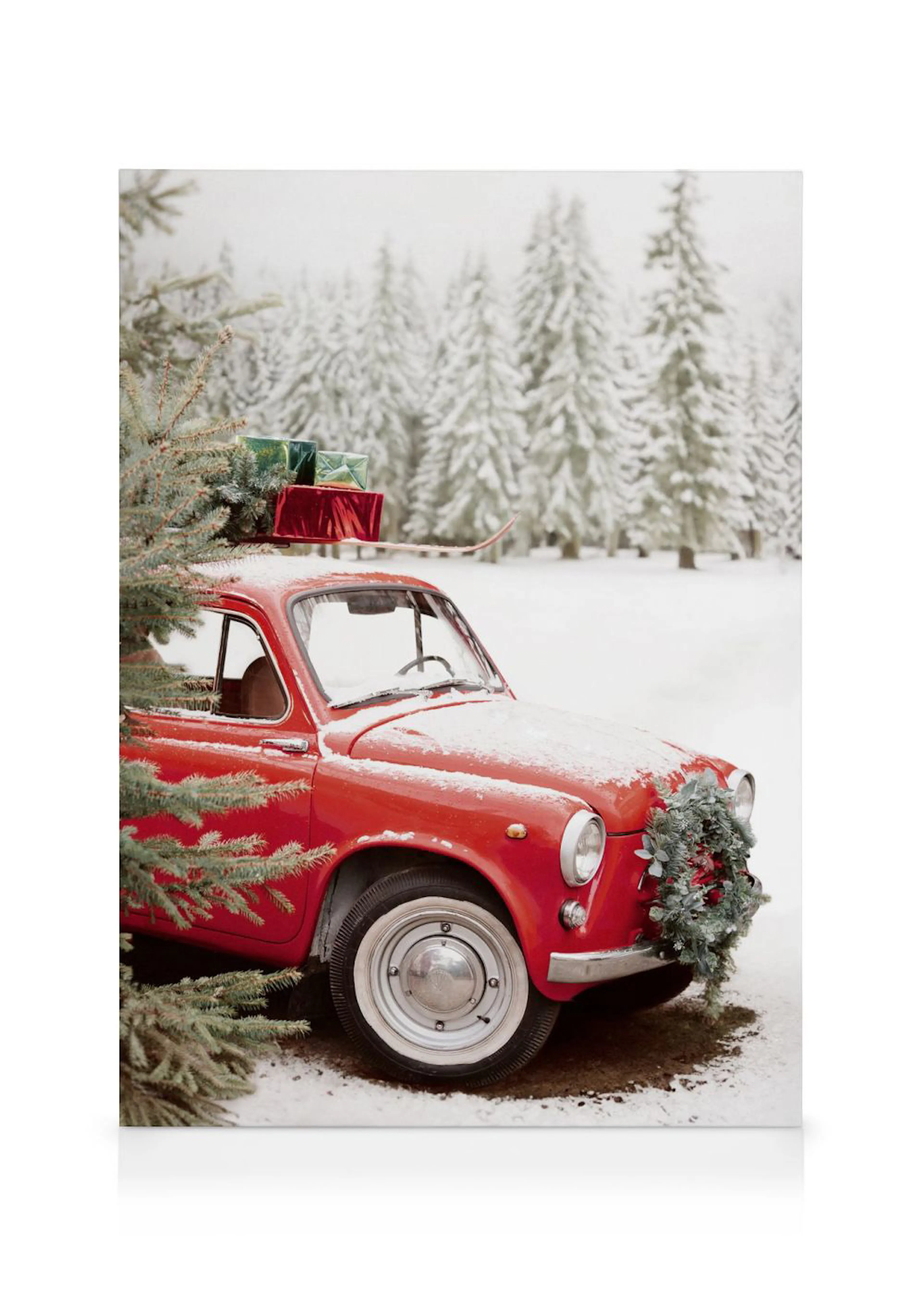 Leinwandbild eines roten Vintage-Autos mit Geschenken und Tannenbaum auf dem Dach im verschneiten Wald.