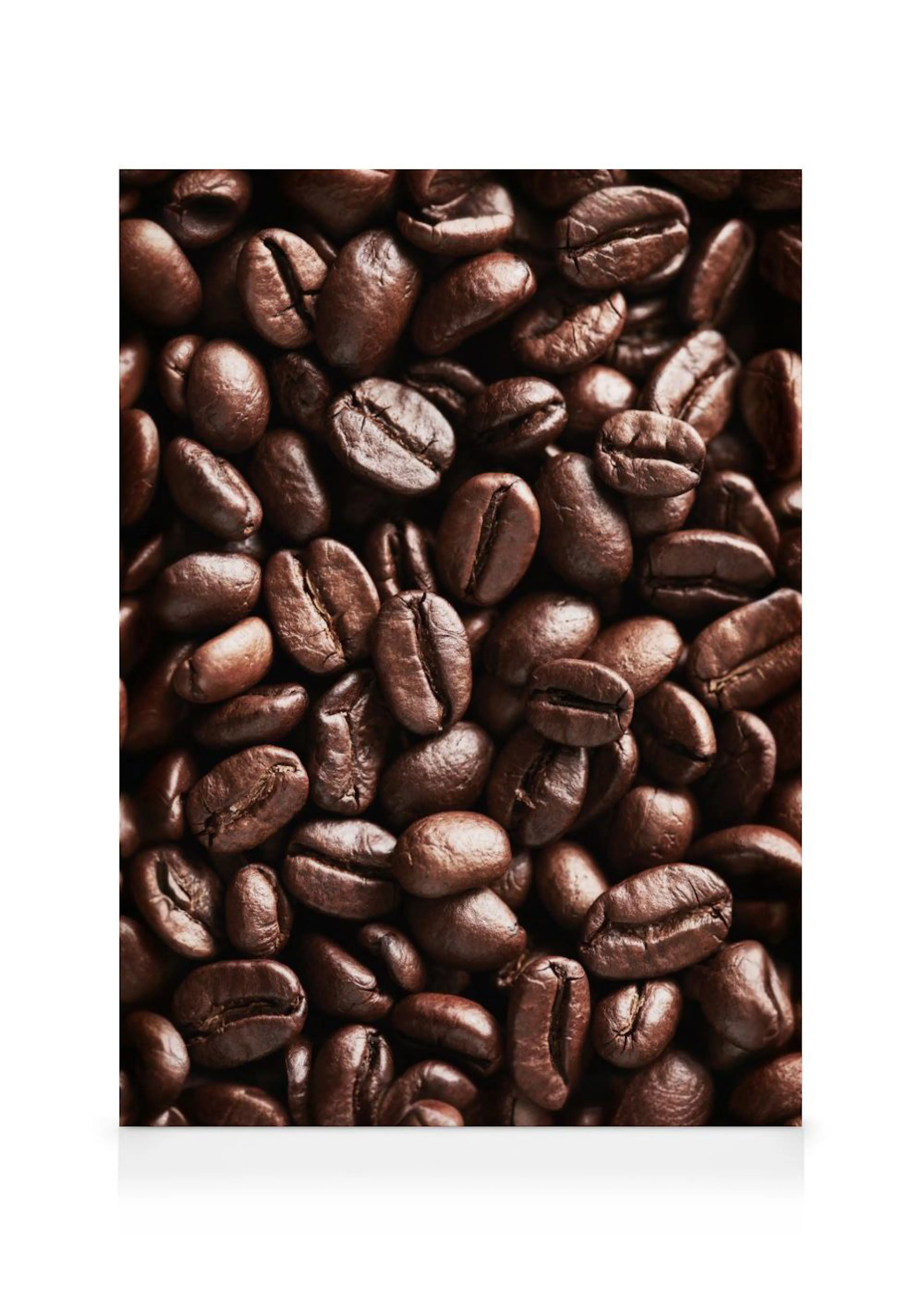 Leinwandbild mit einer Nahaufnahme glänzender, dunkelbrauner Kaffeebohnen, die dicht beieinander liegen.