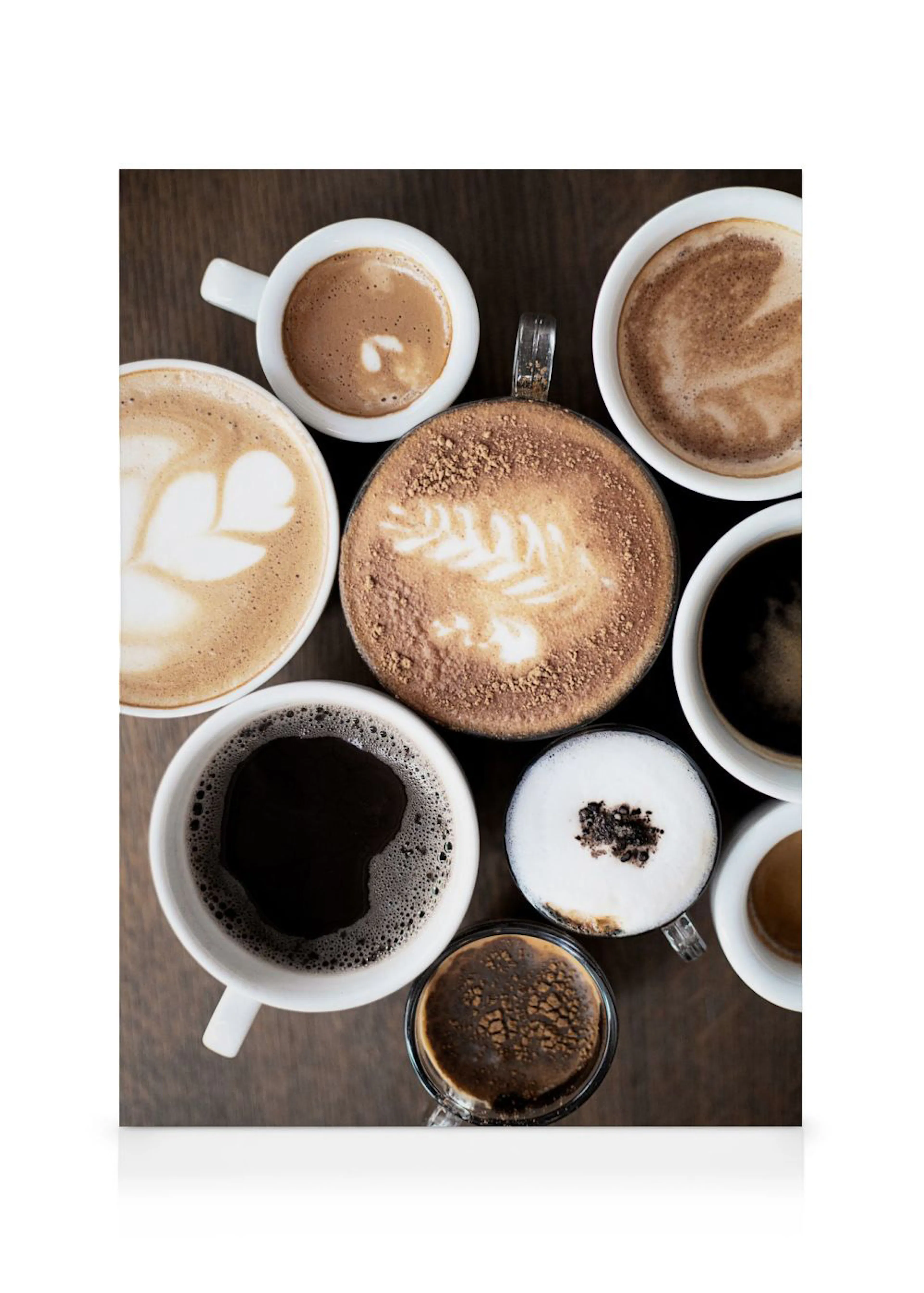 Toile vue de dessus de plusieurs tasses de café avec diverses préparations et latte art sur une table en bois.