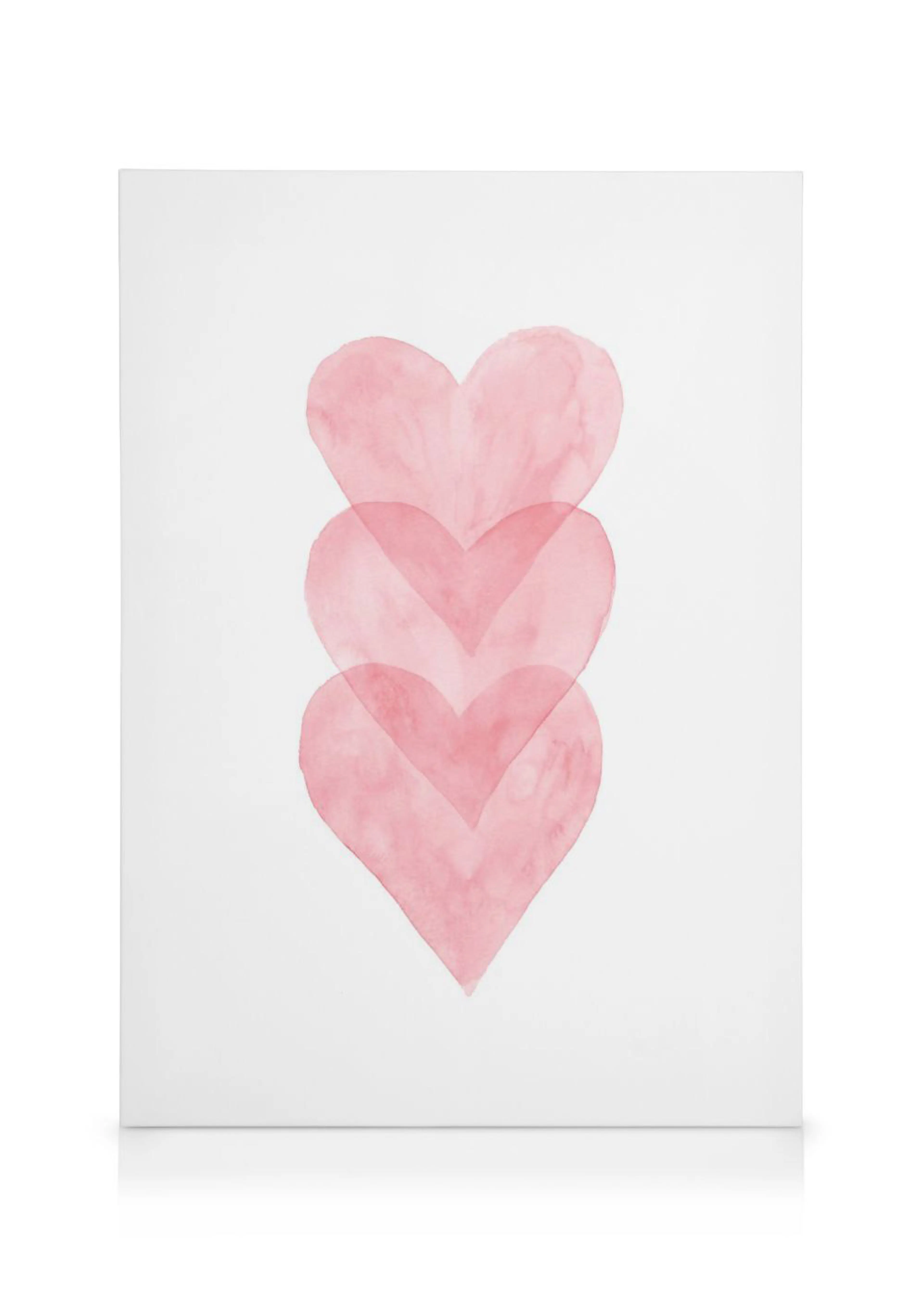 A canvas featuring three translucent pink watercolor hearts stacked vertically on a white background.