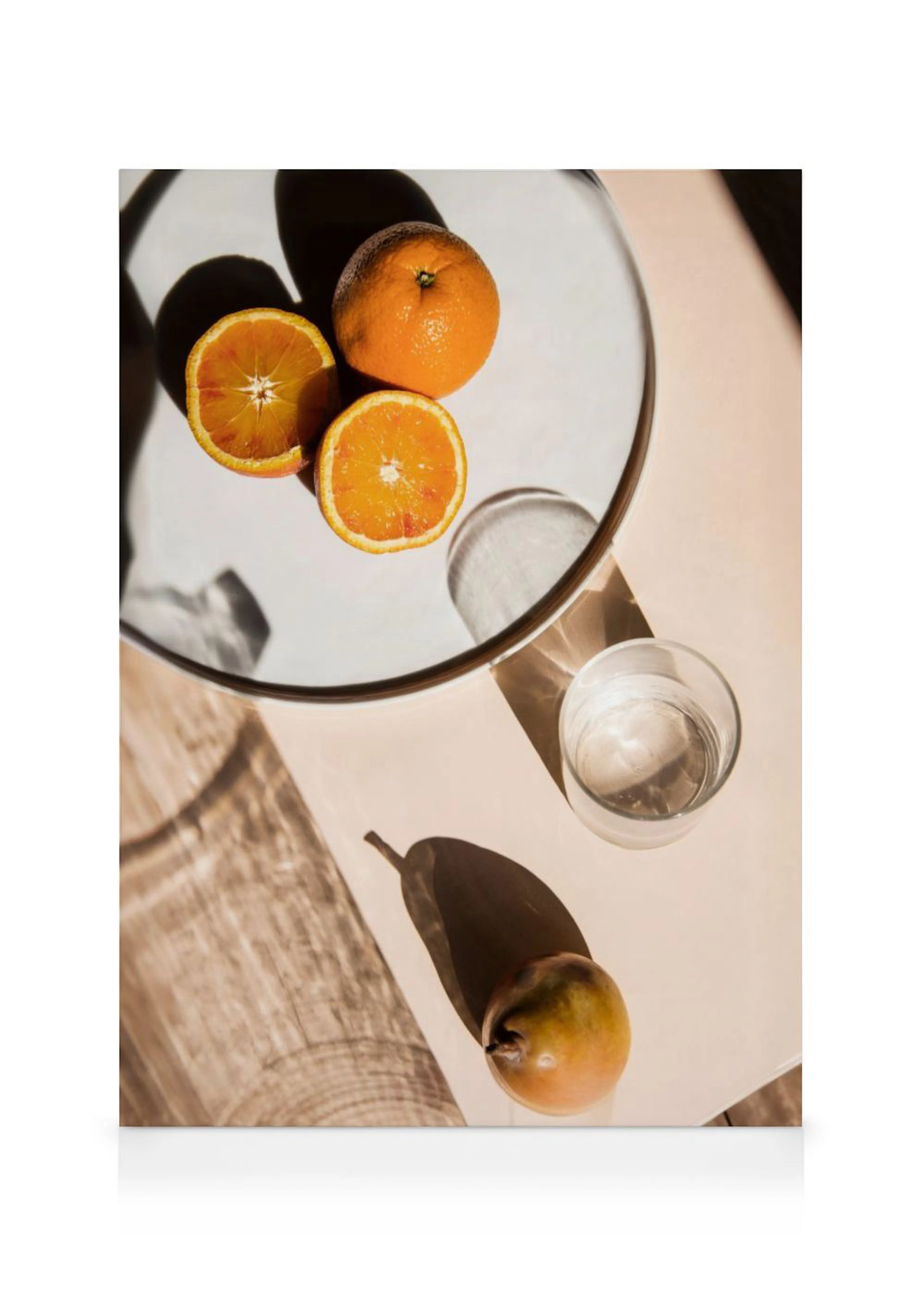 A canvas displaying two whole and two sliced oranges on a mirror, with a glass of water and a pear beside it.