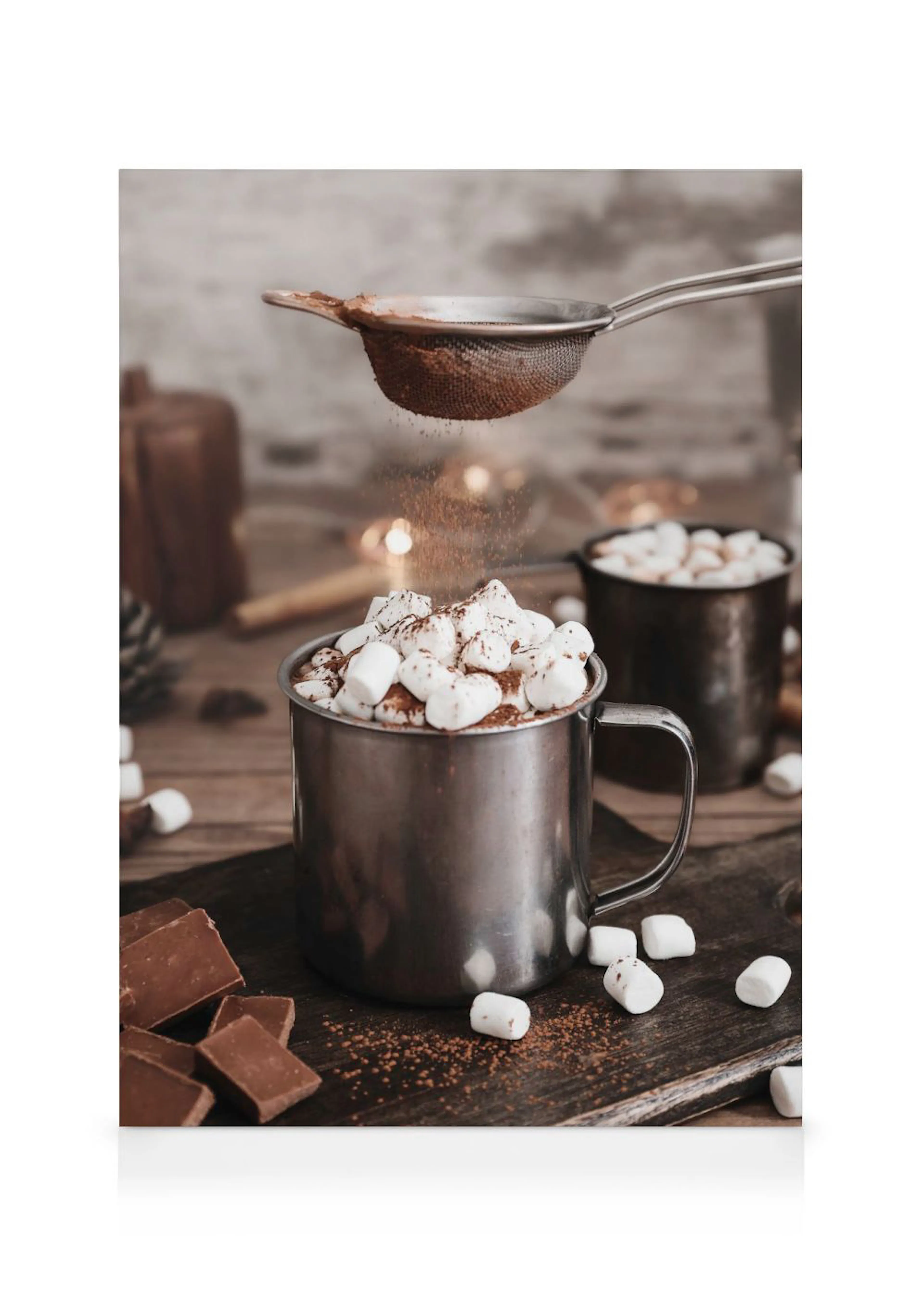 Toile de chocolat chaud garni de guimauves et saupoudré de cacao en poudre, avec des morceaux de chocolat.
