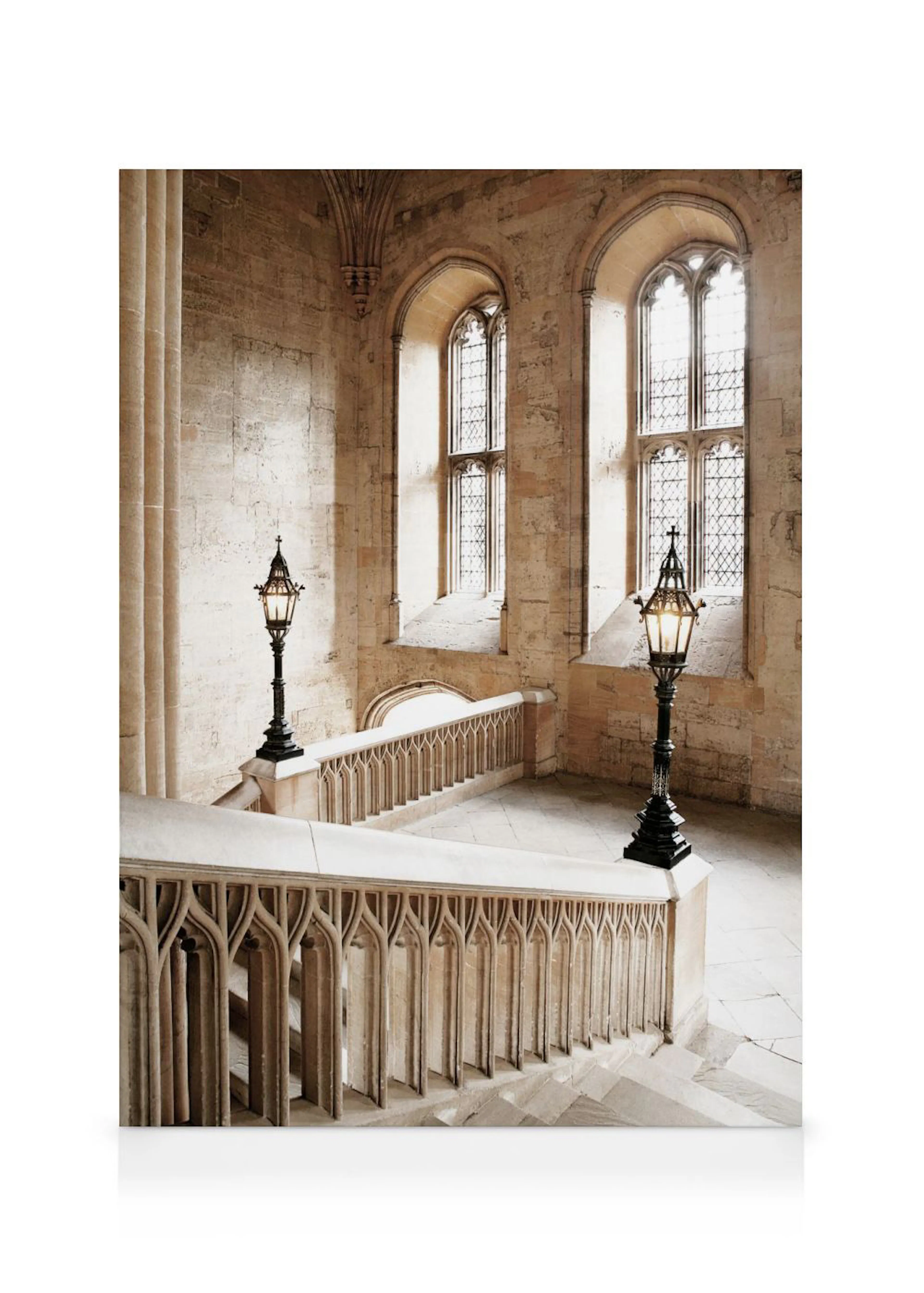 Toile dun escalier en pierre de style gothique avec des balustrades sculptées et deux lampadaires anciens, éclairé par la lumièr