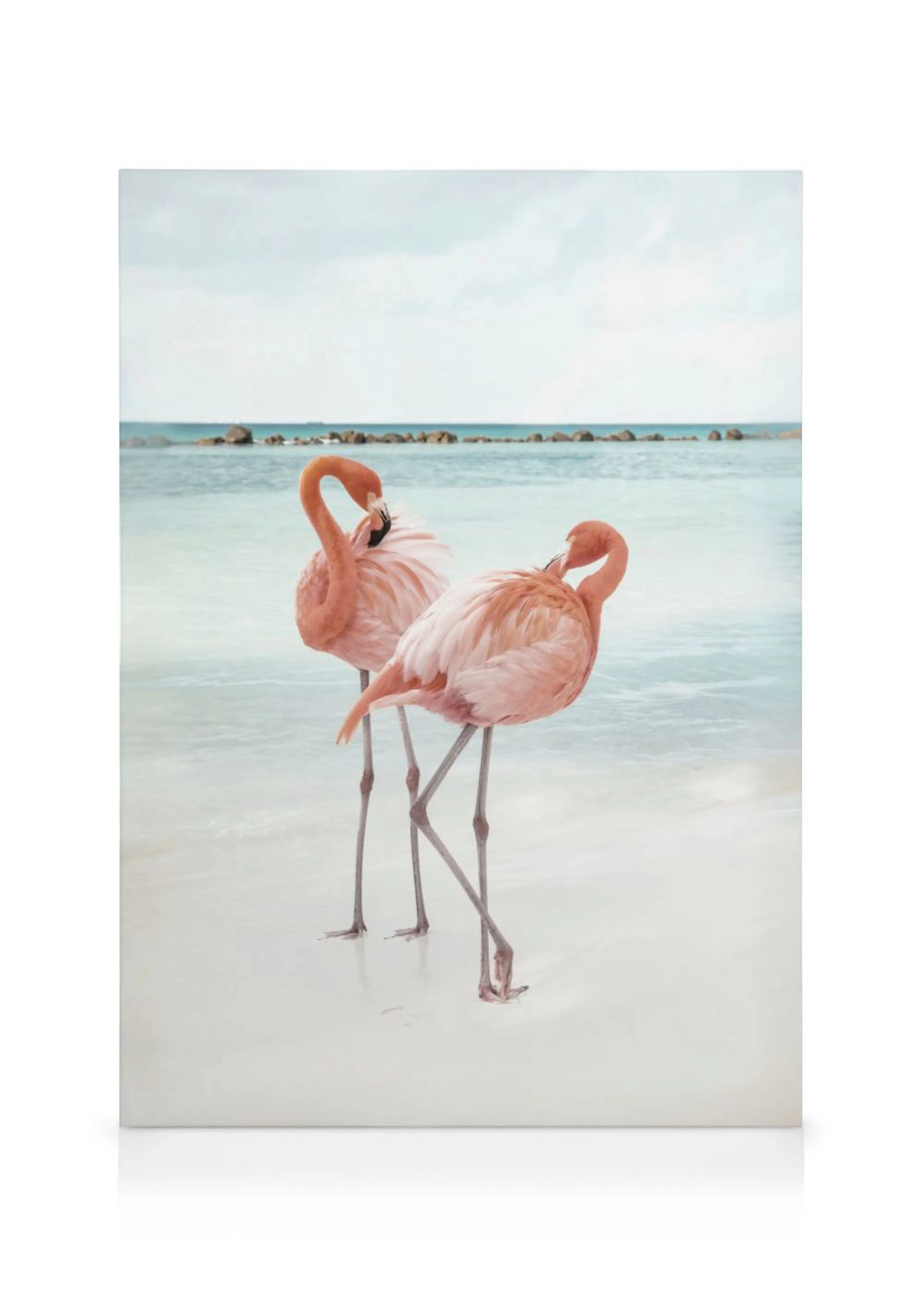 Leinwandbild mit zwei rosa Flamingos, die im seichten türkisfarbenen Wasser am weißen Sandstrand stehen.