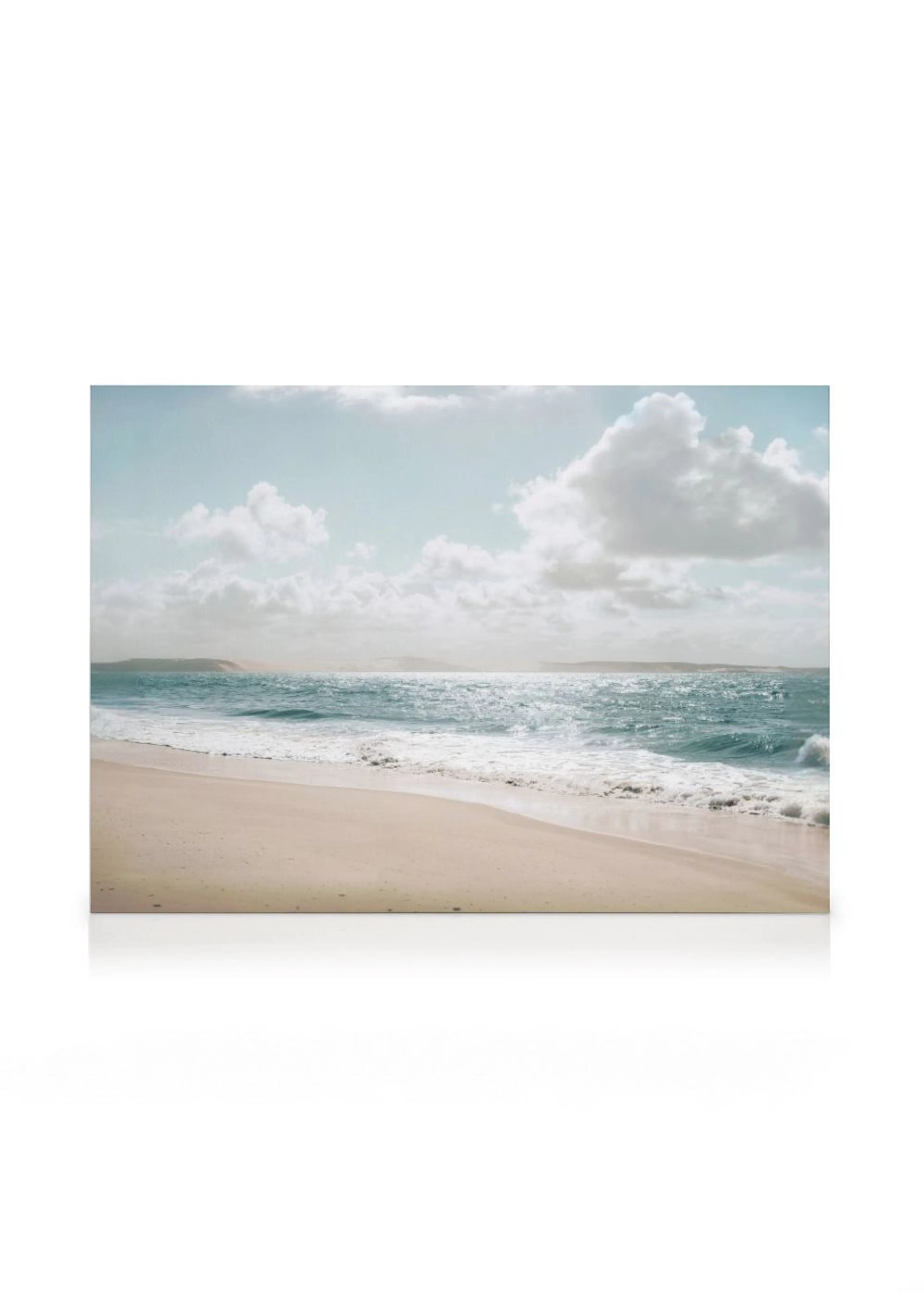 A canvas capturing a tranquil beach scene with light beige sand and blue ocean waves under a bright sky with white clouds.