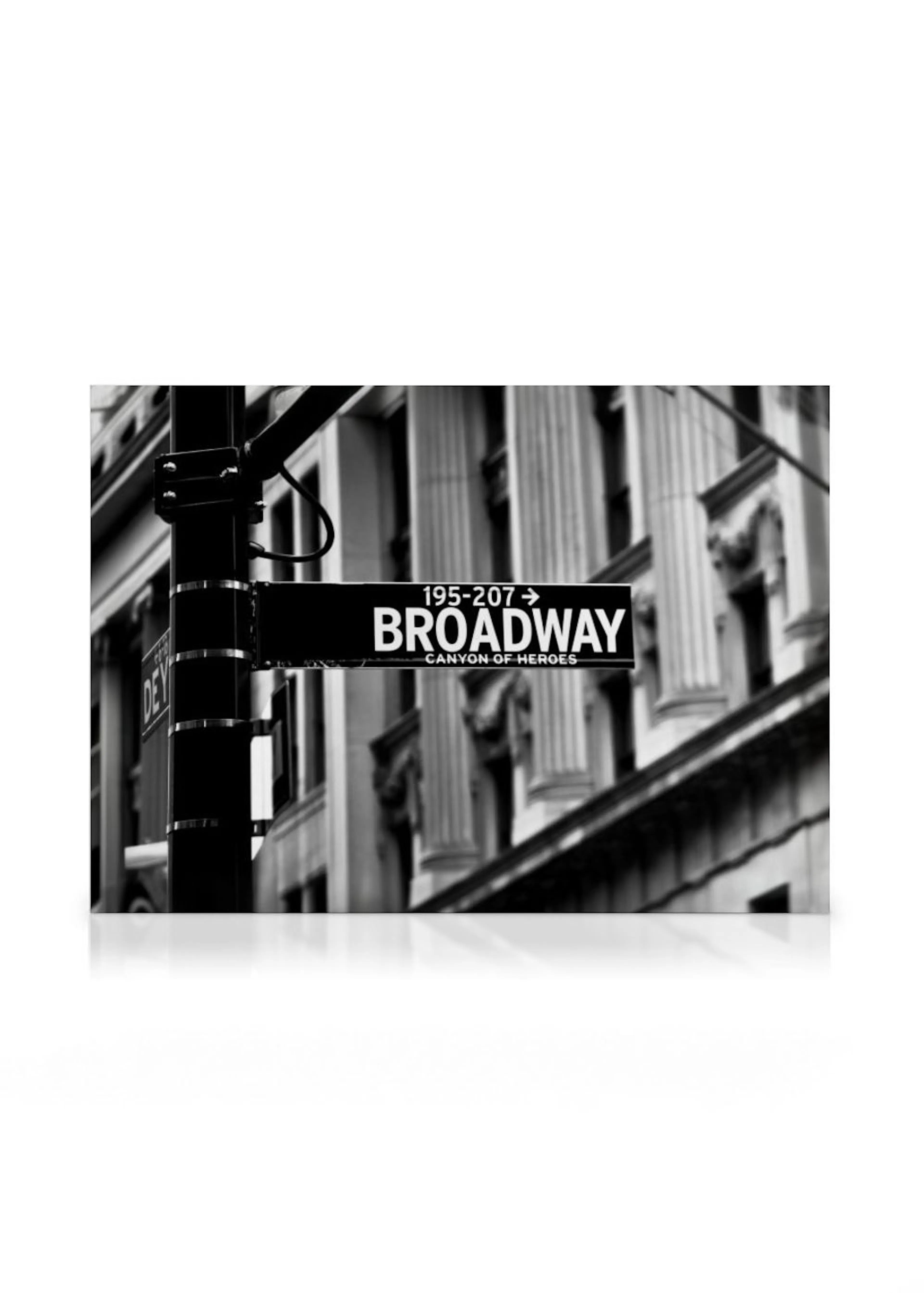 En svartvit canvastavla med en Broadway-skylt och en byggnad med pelare i bakgrunden.