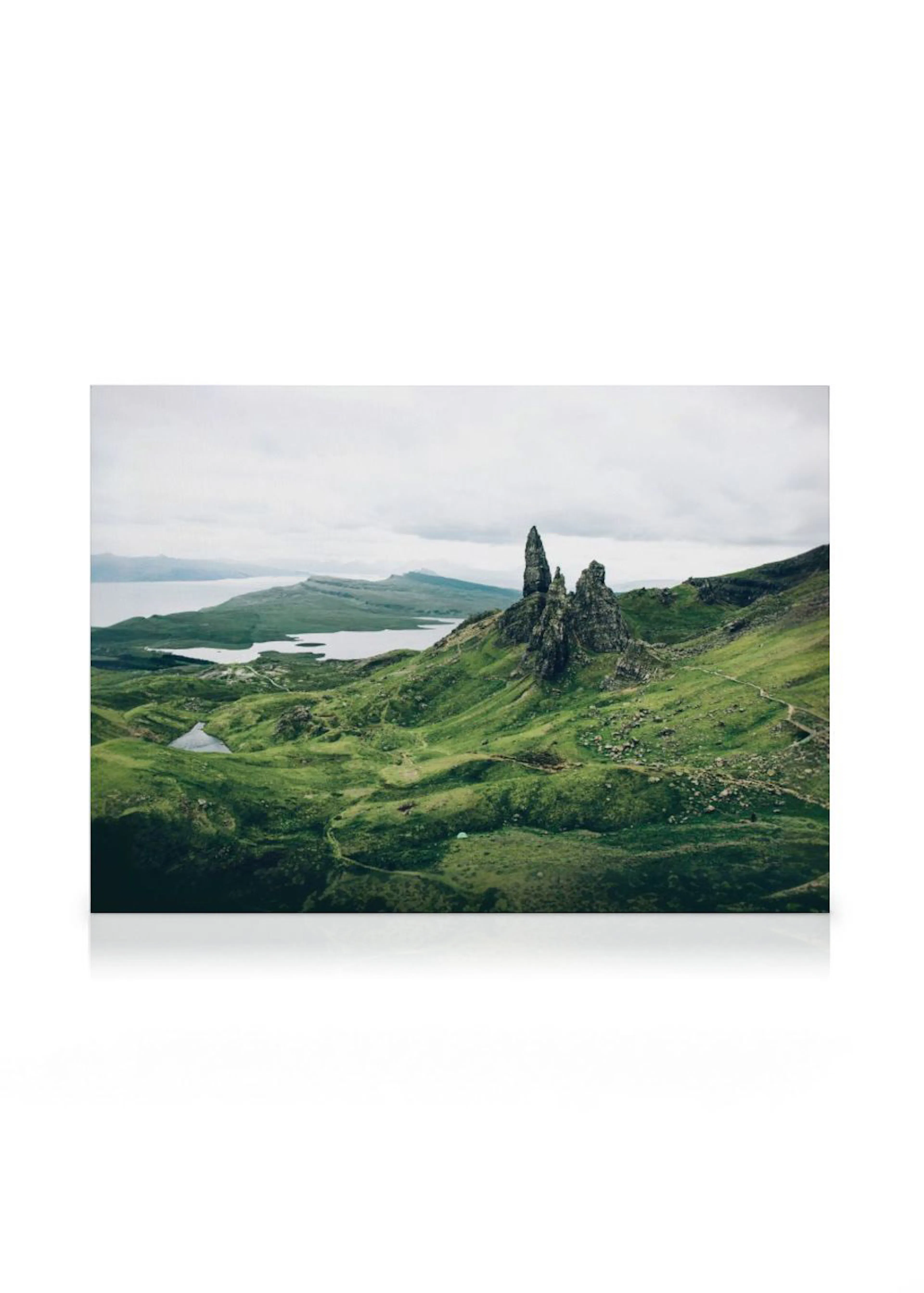 A canvas displaying a landscape of rolling green hills, a large rock formation, and a lake under a cloudy sky.