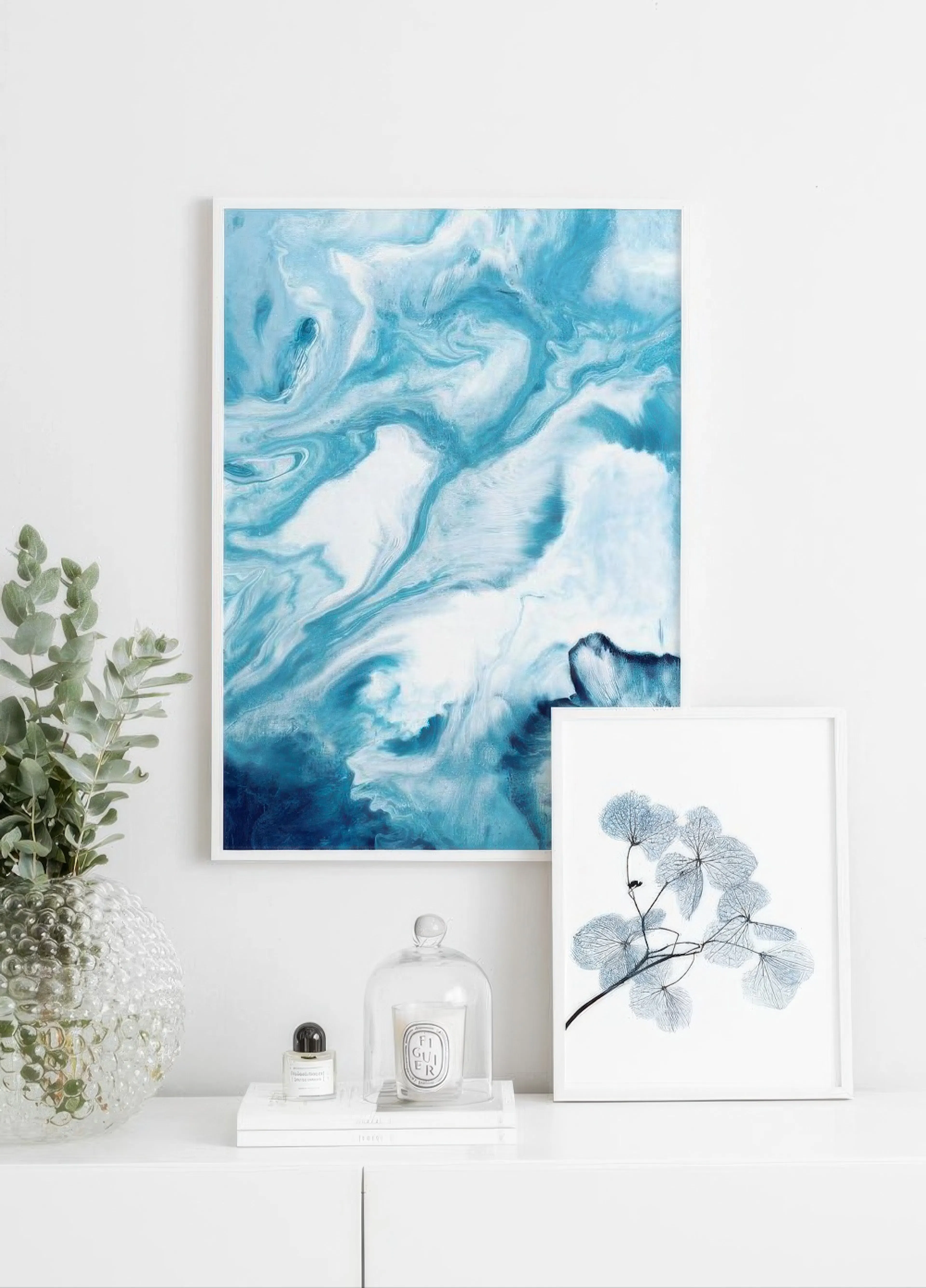 Abstract blue and white marble print displayed on a white console table with a plant and decor.