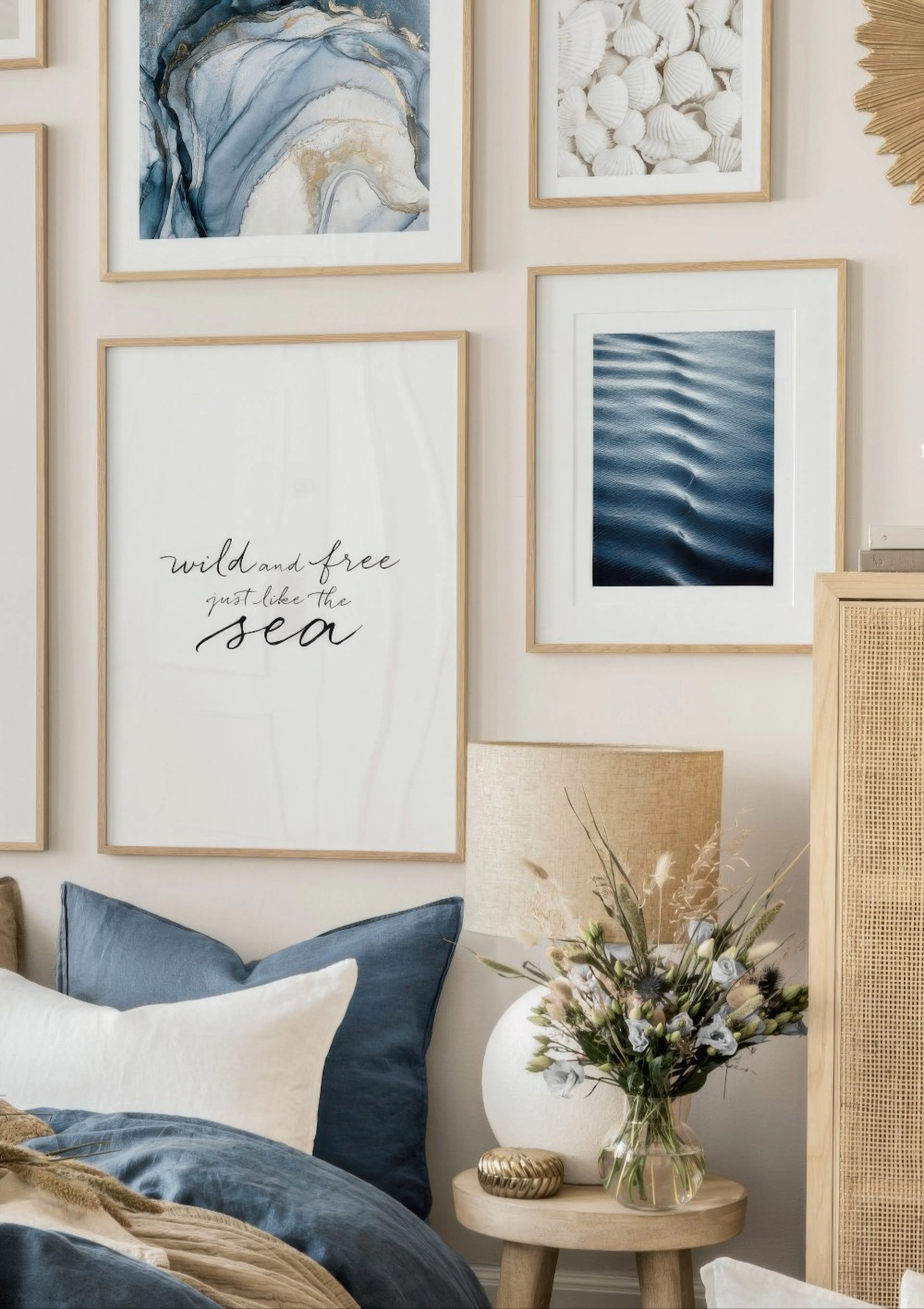 Plakat z napisem wild and free just like the sea w sypialni z niebieskimi poduszkami i lampą.