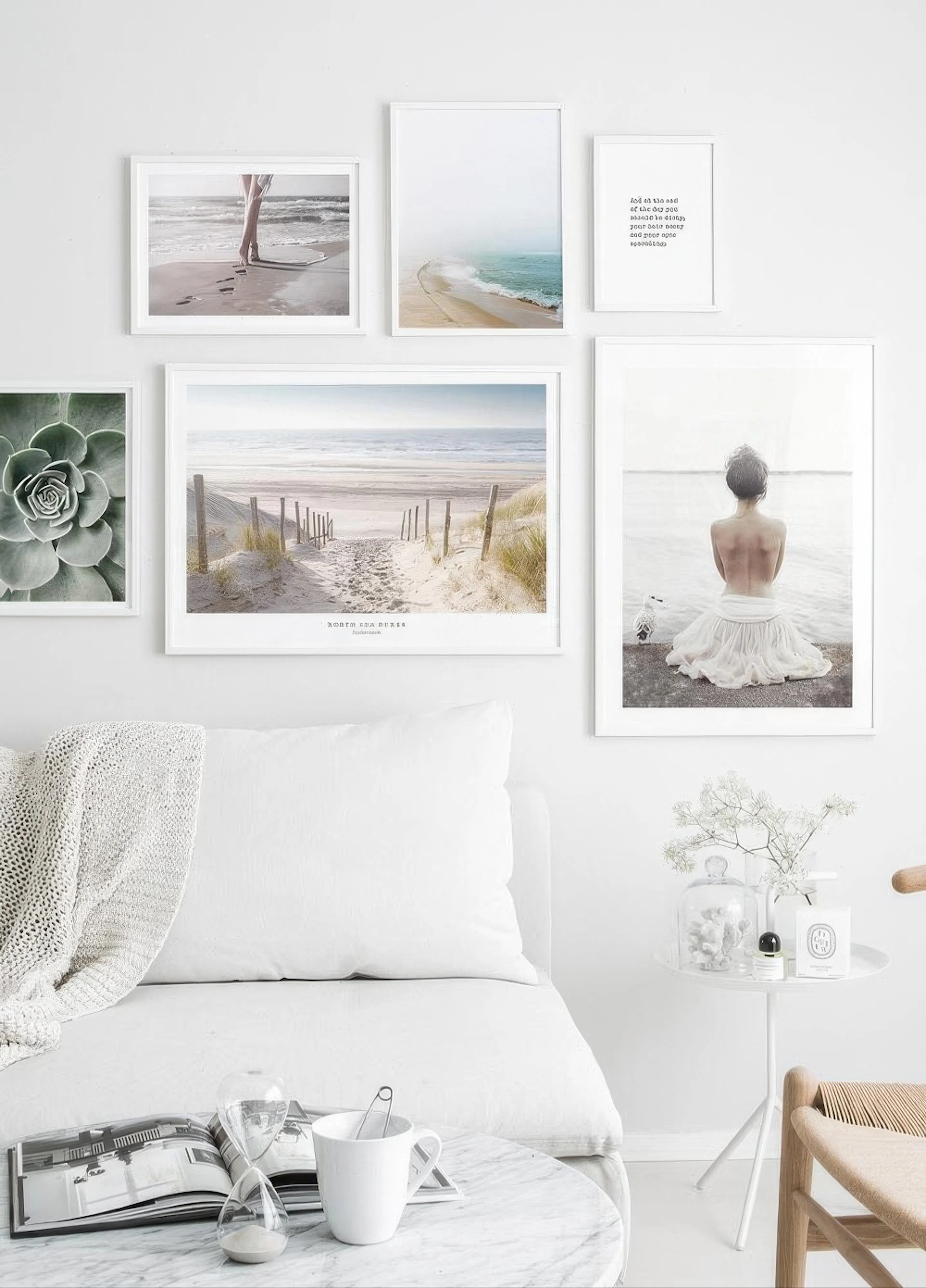 A gallery wall of six coastal and serene prints, including beach scenes and a succulent, displayed above a white sofa.
