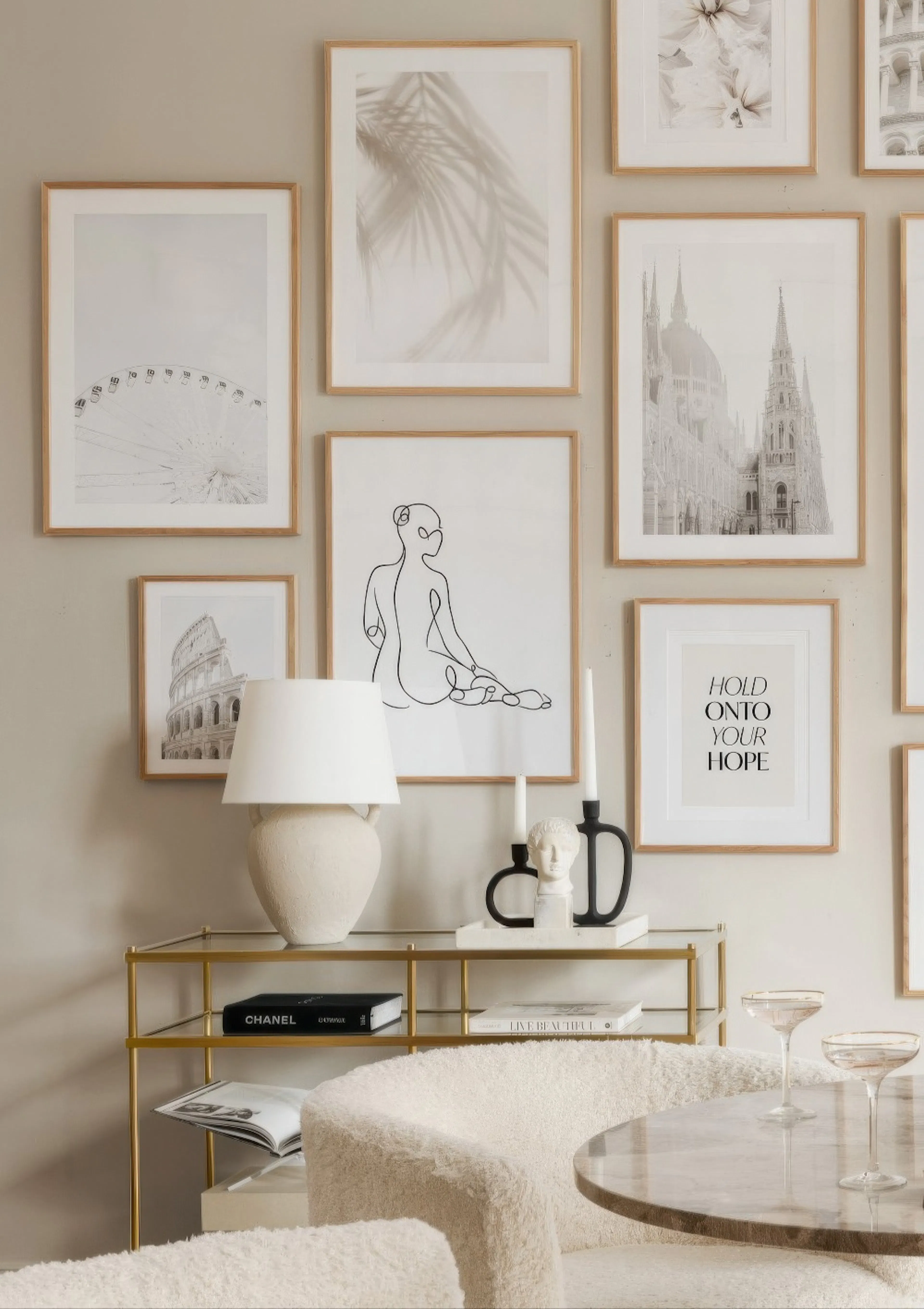 A gallery wall featuring posters of a Ferris wheel, palm leaves, a line art figure, the Colosseum, a cathedral, and a quote, dis