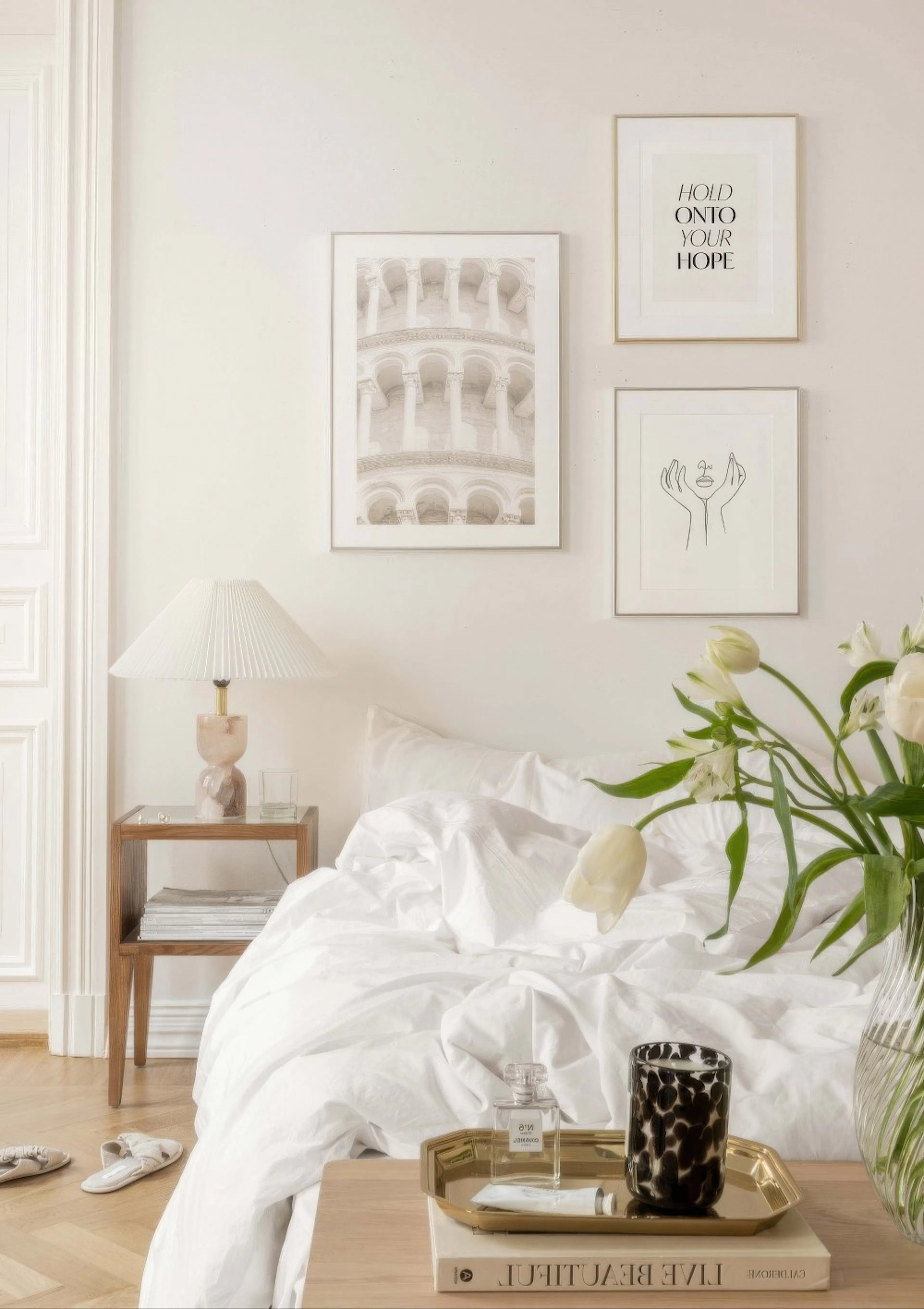 A gallery wall with three posters: a sepia print of the Leaning Tower of Pisa, a text print saying HOLD ONTO YOUR HOPE, and a li