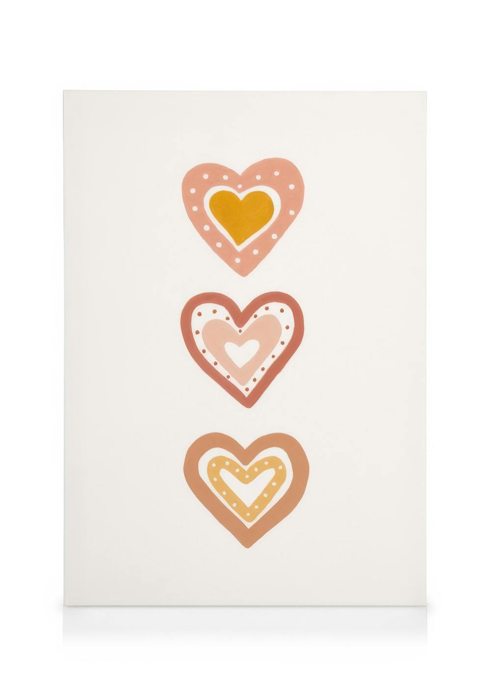 Toile murale blanche avec trois coeurs décoratifs aux teintes rose, orange et marron.