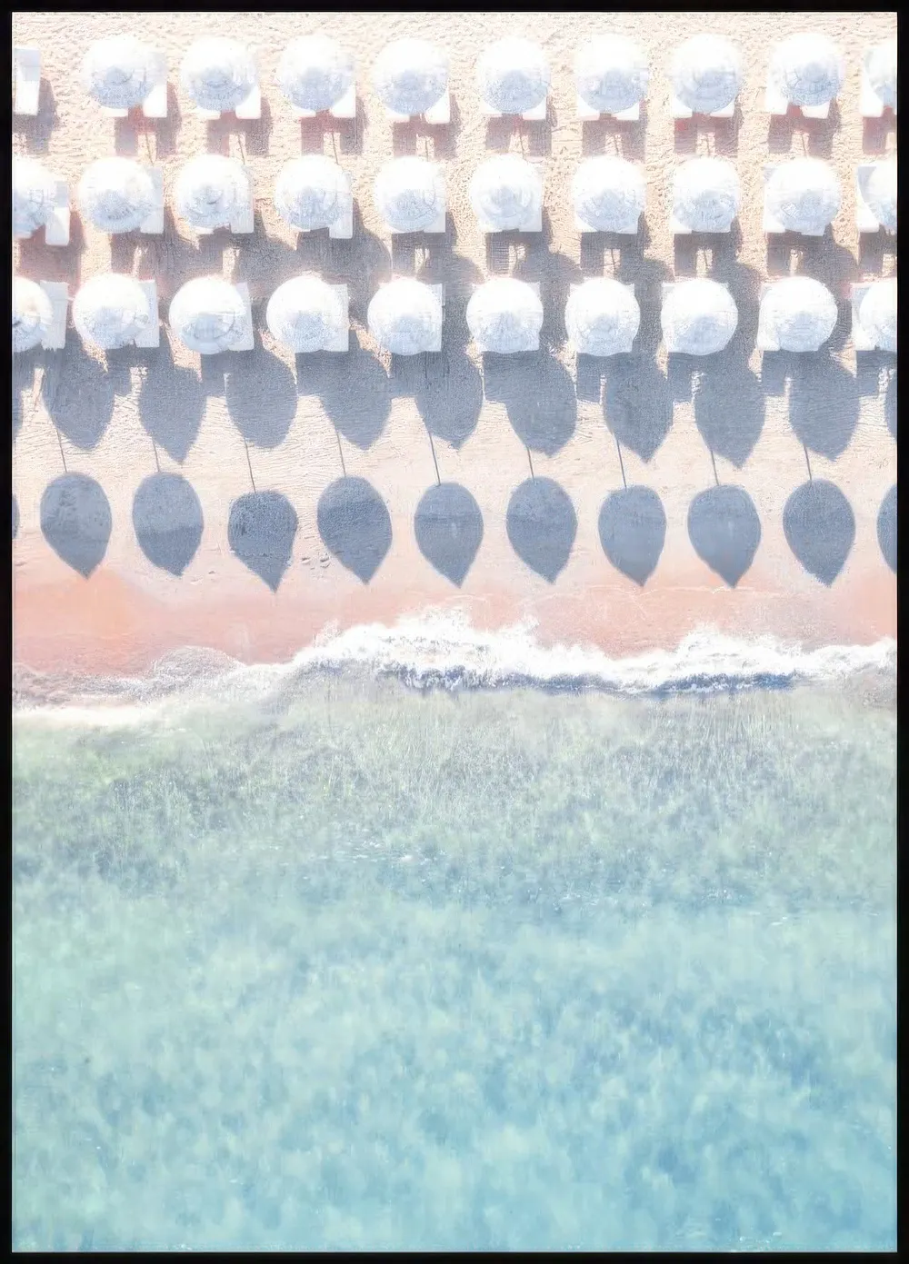 Plakat przedstawiający widok z lotu ptaka na plażę z rzędami białych parasoli rzucających cienie, różowym piaskiem i turkusowymi