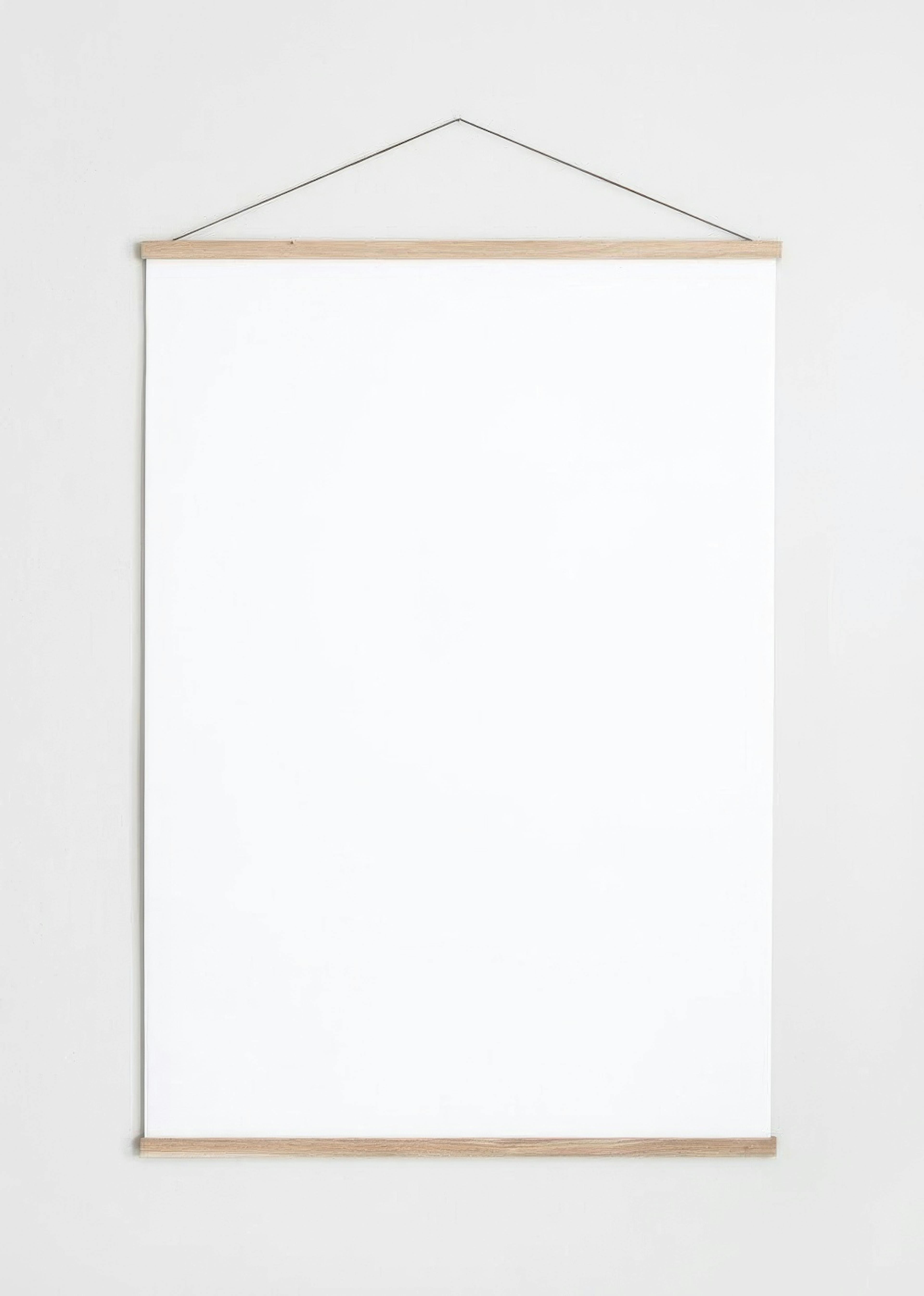 A blank white poster, suspended by a subtle wooden hanger on a light grey wall.