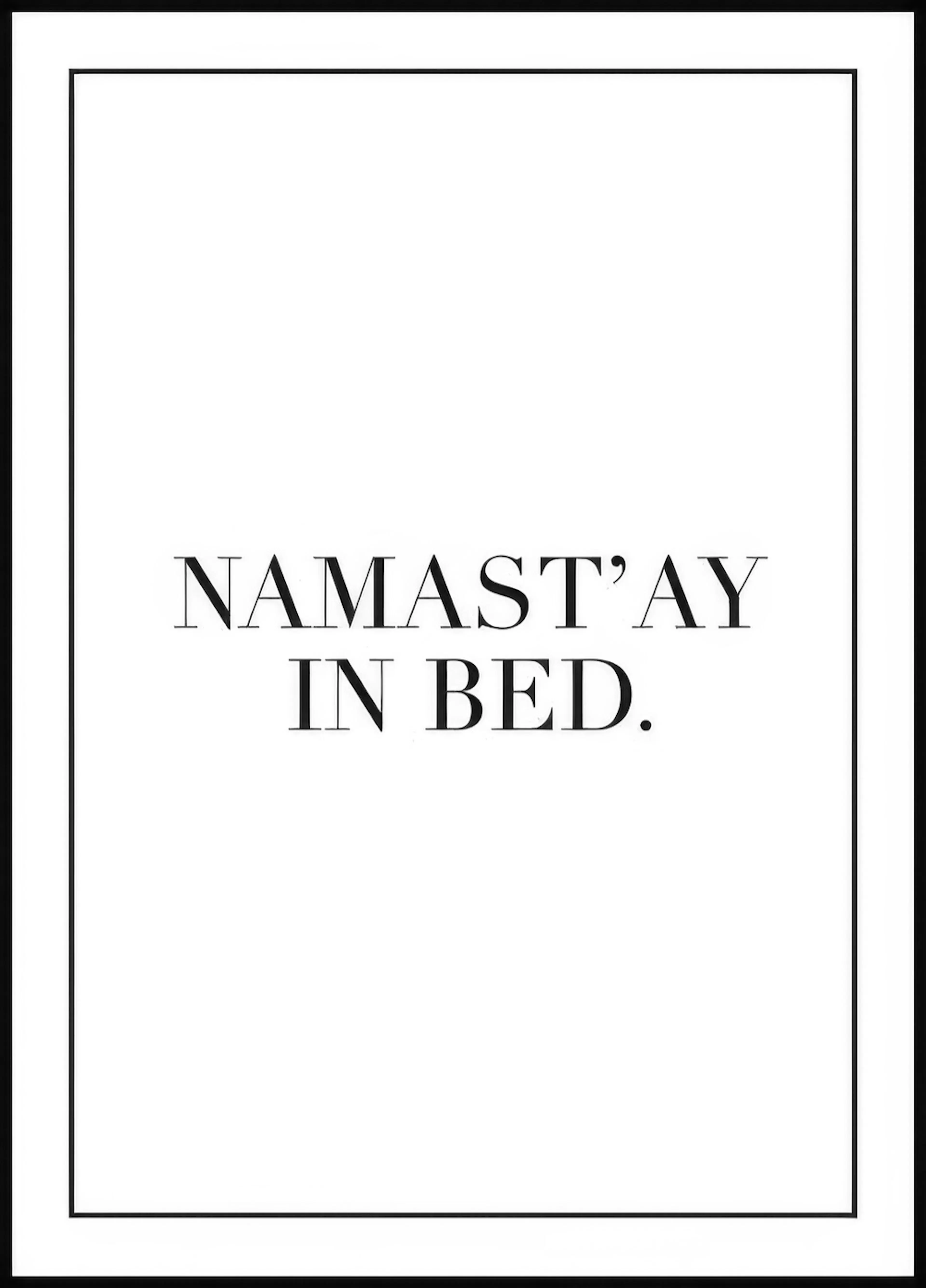 A poster with the text NAMASTAY IN BED. in black serif font on a white background.